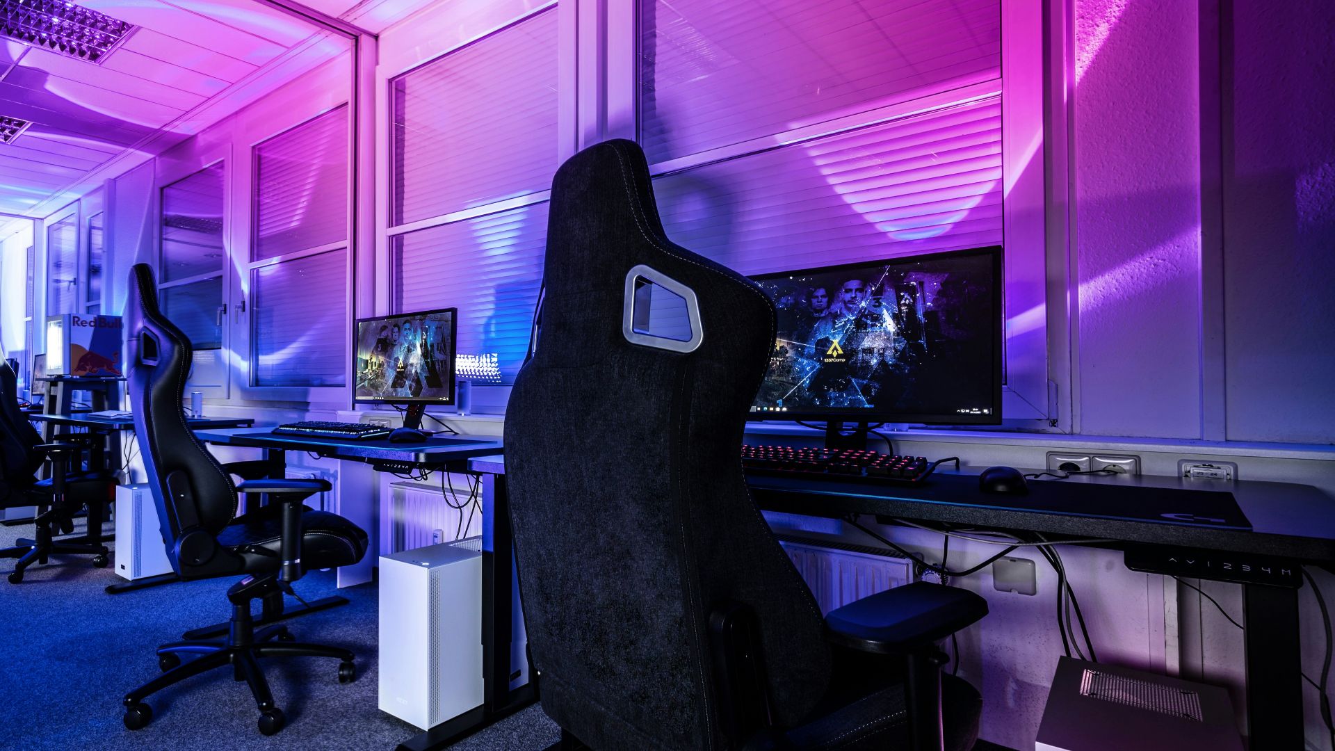 a room filled with lots of computer desks and chairs