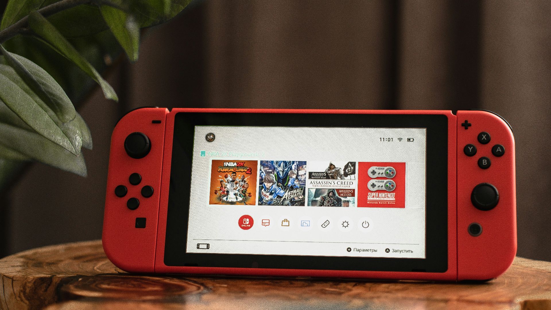 red nintendo switch on brown wooden table