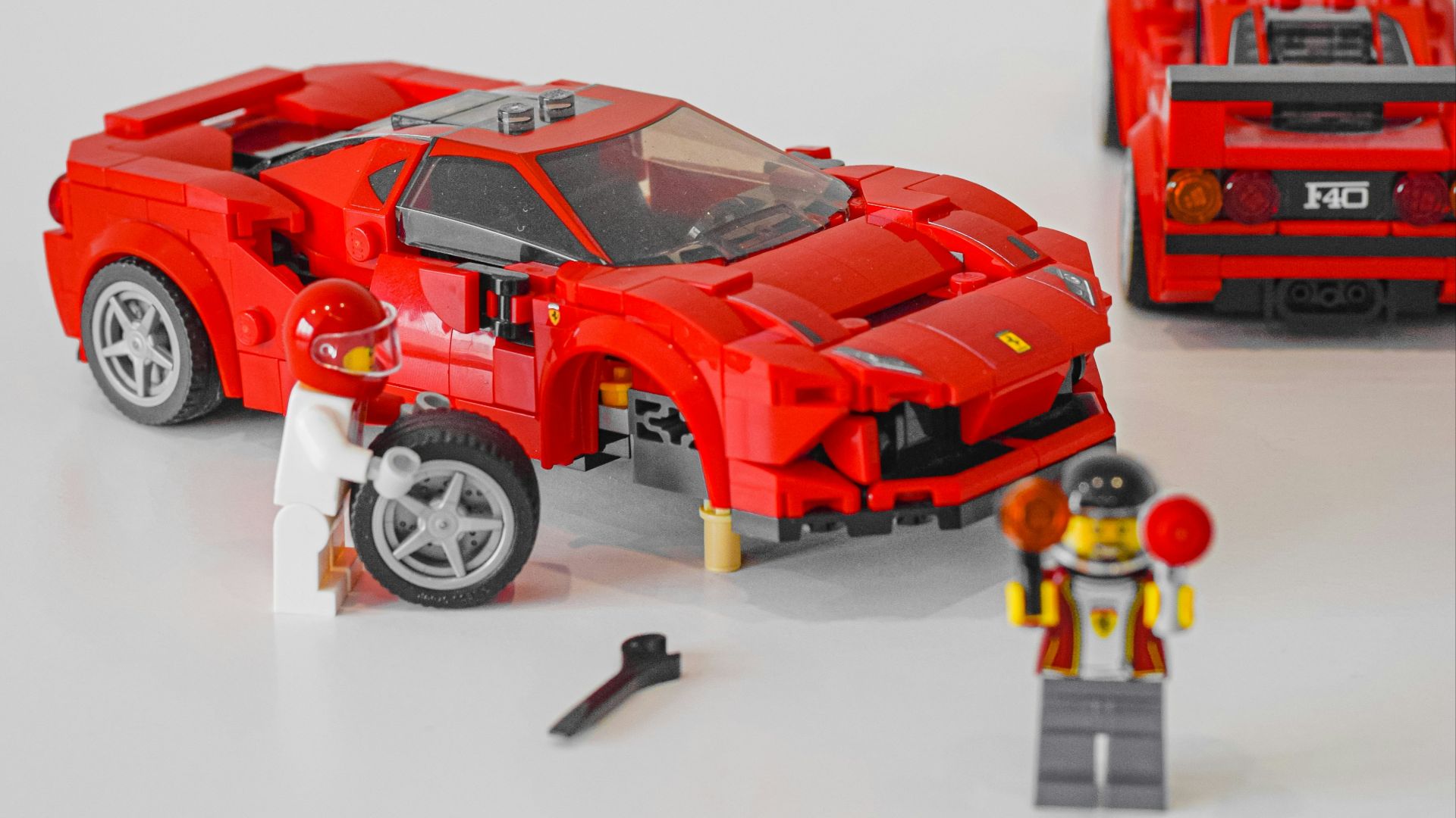 a couple of red lego cars sitting on top of a table