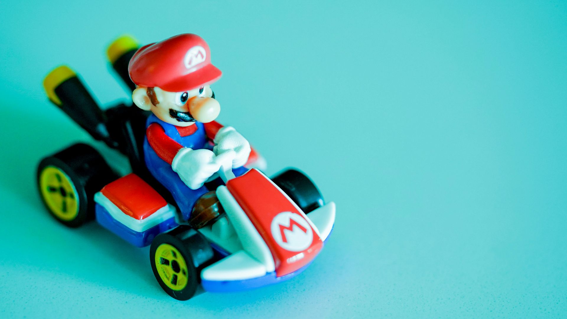 red haired man riding red and blue car plastic toy
