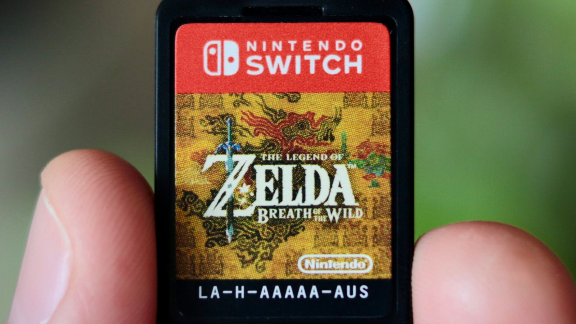 a hand holding a nintendo wii game card