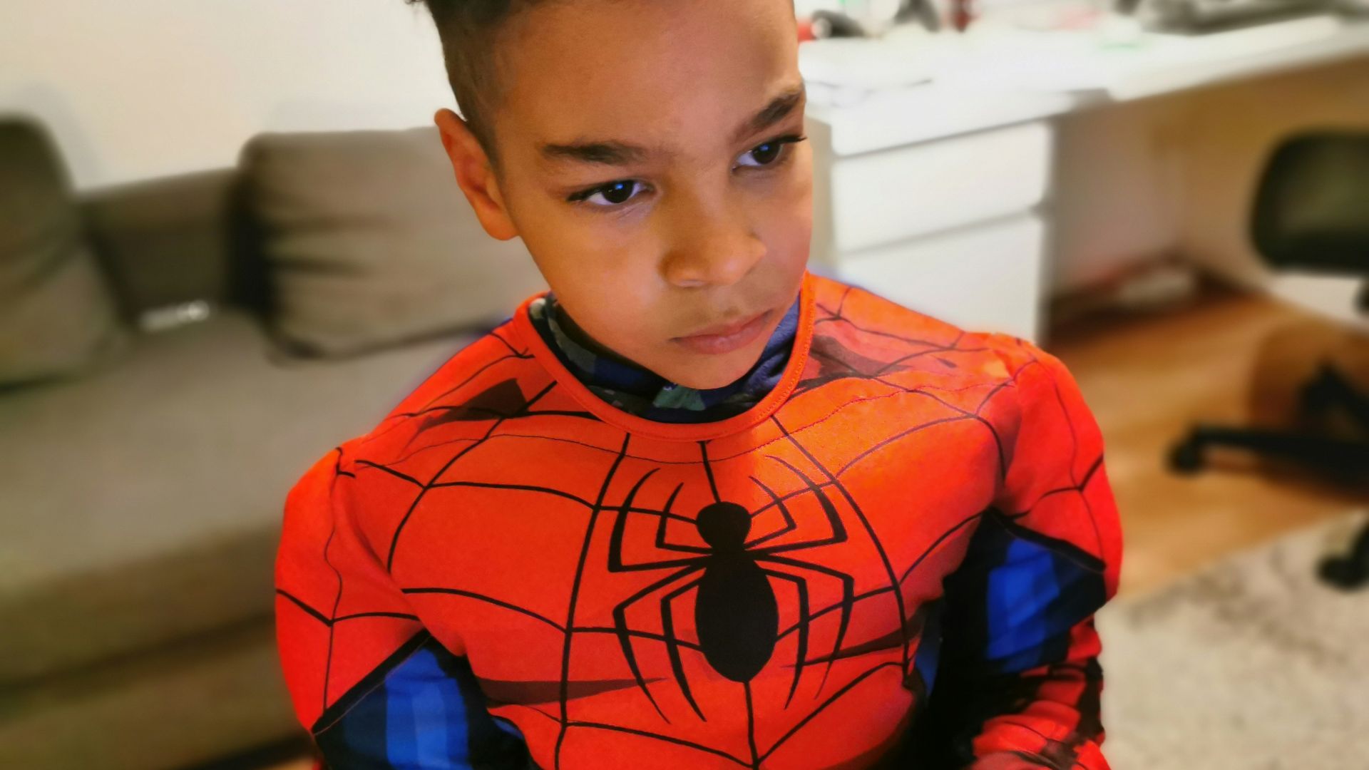 a young boy wearing a spider man costume