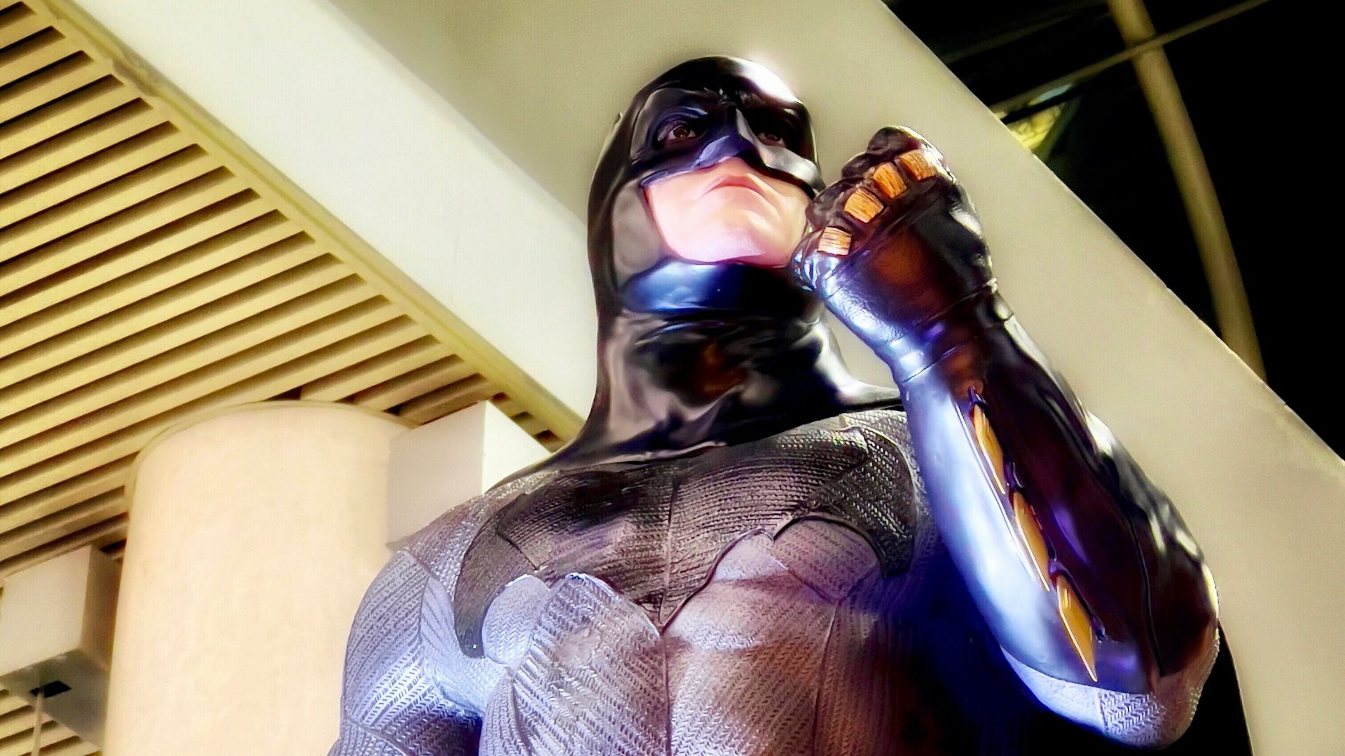 a man in a batman costume drinking from a bottle