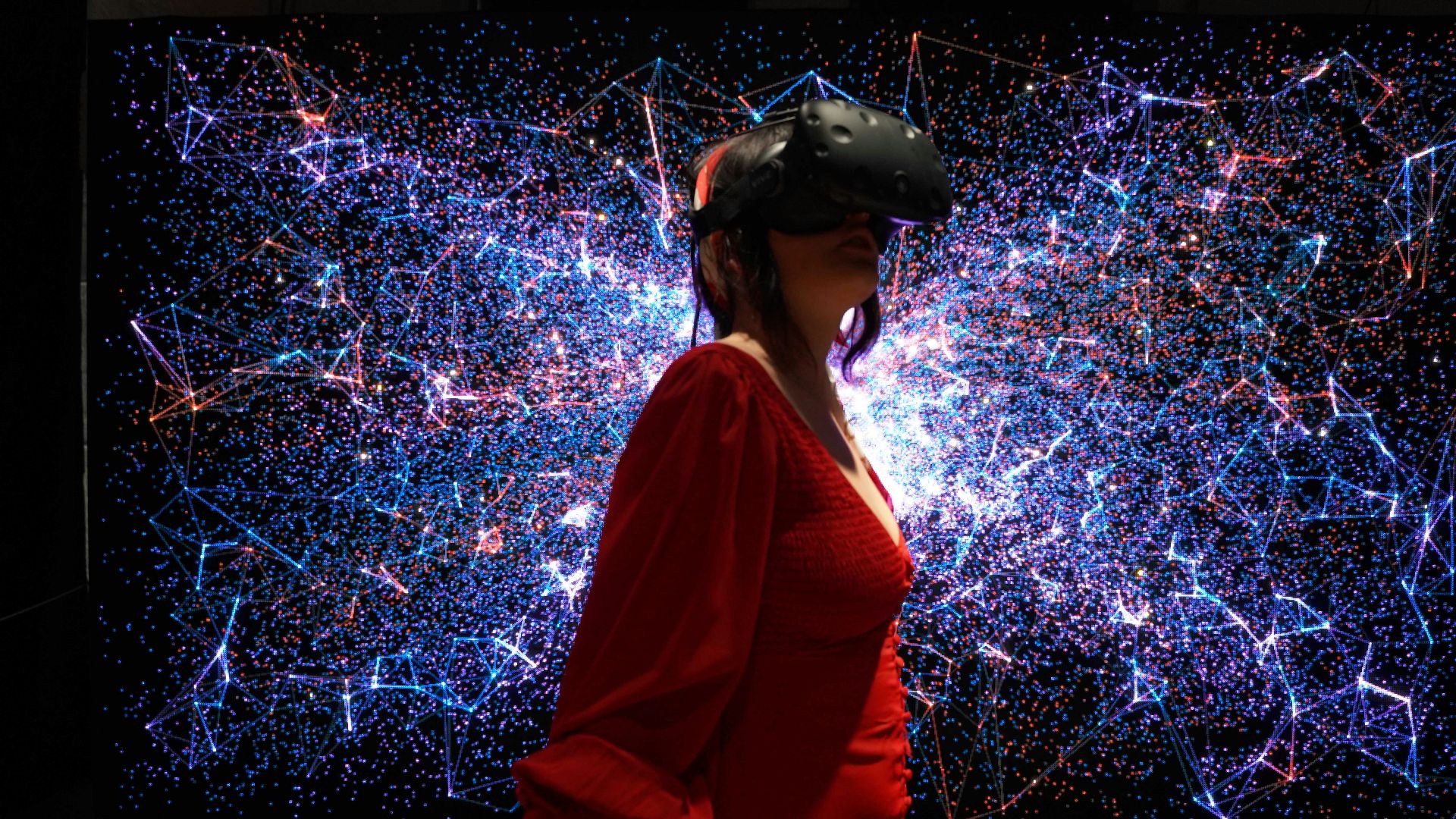 a woman in a red dress wearing a virtual reality headset