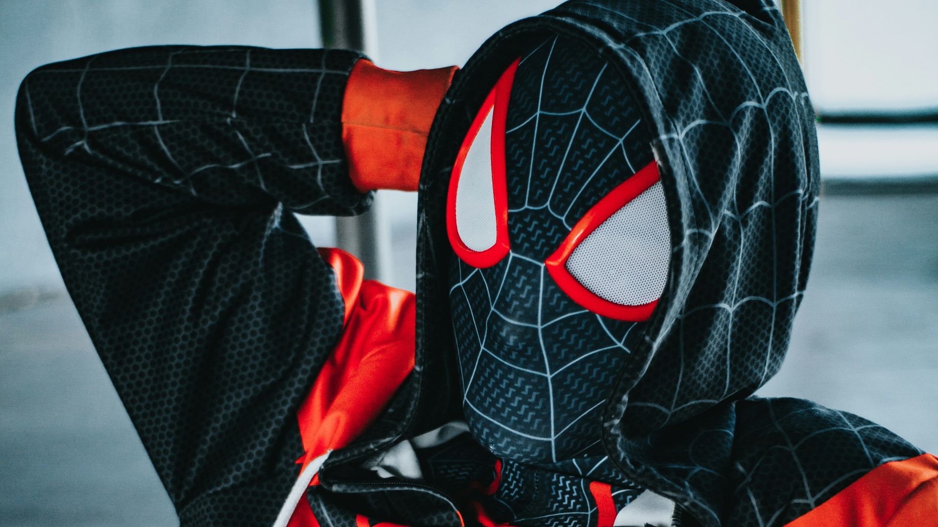 a spider man is sitting on a bench