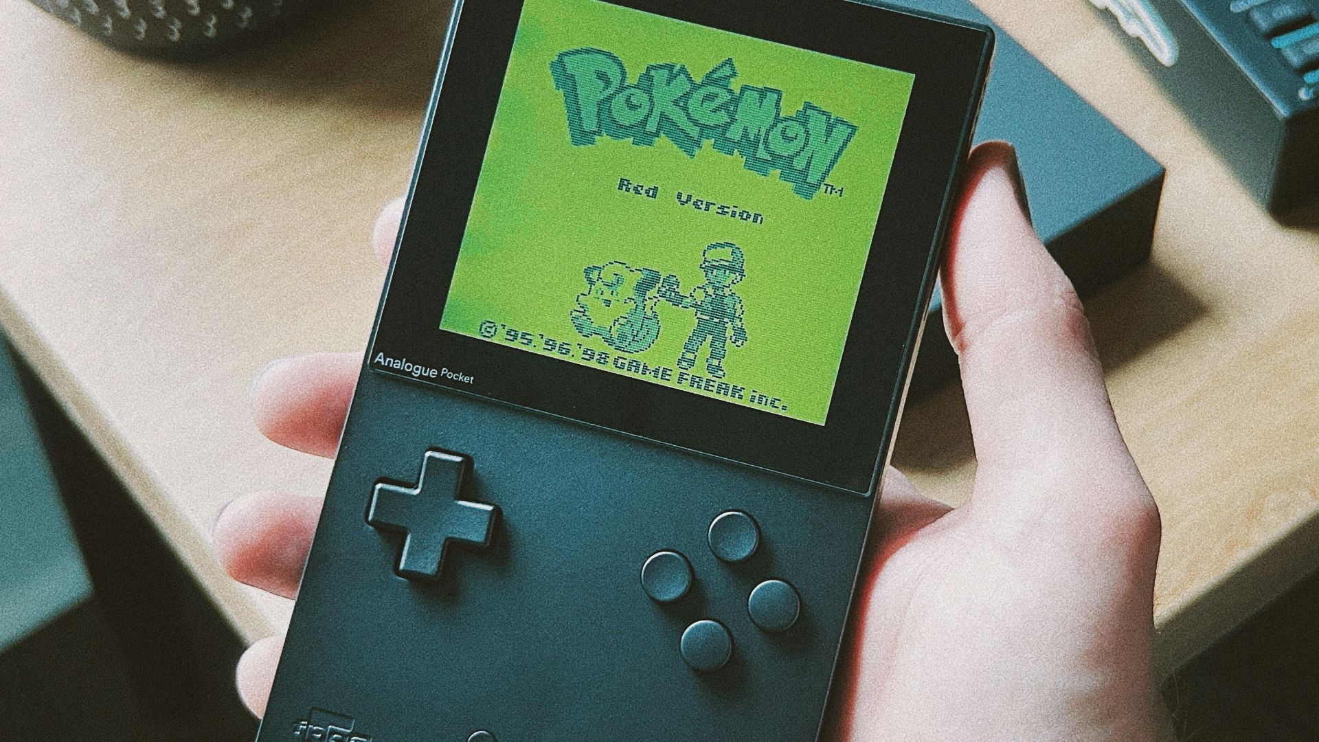 a person holding a gameboy in their hand