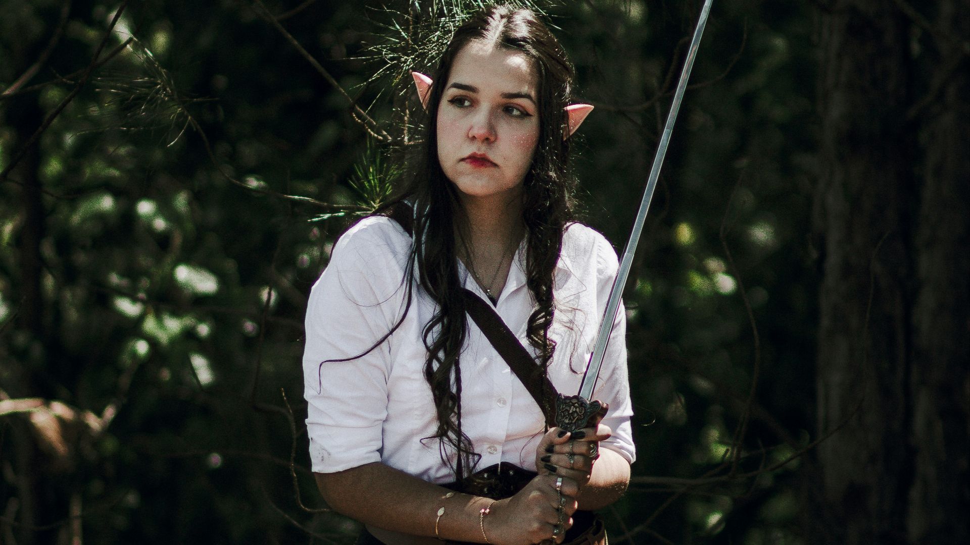 a woman in a white shirt and black skirt holding a sword