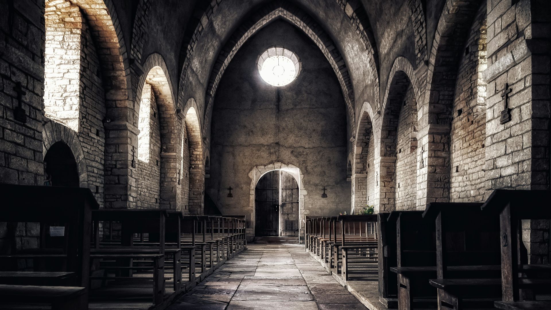 an empty church with pews and a bright window
