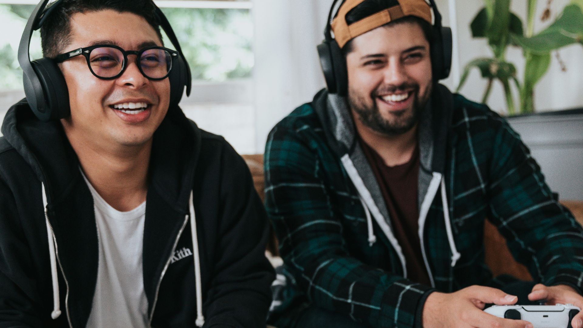 a couple of men sitting at a table with game controllers