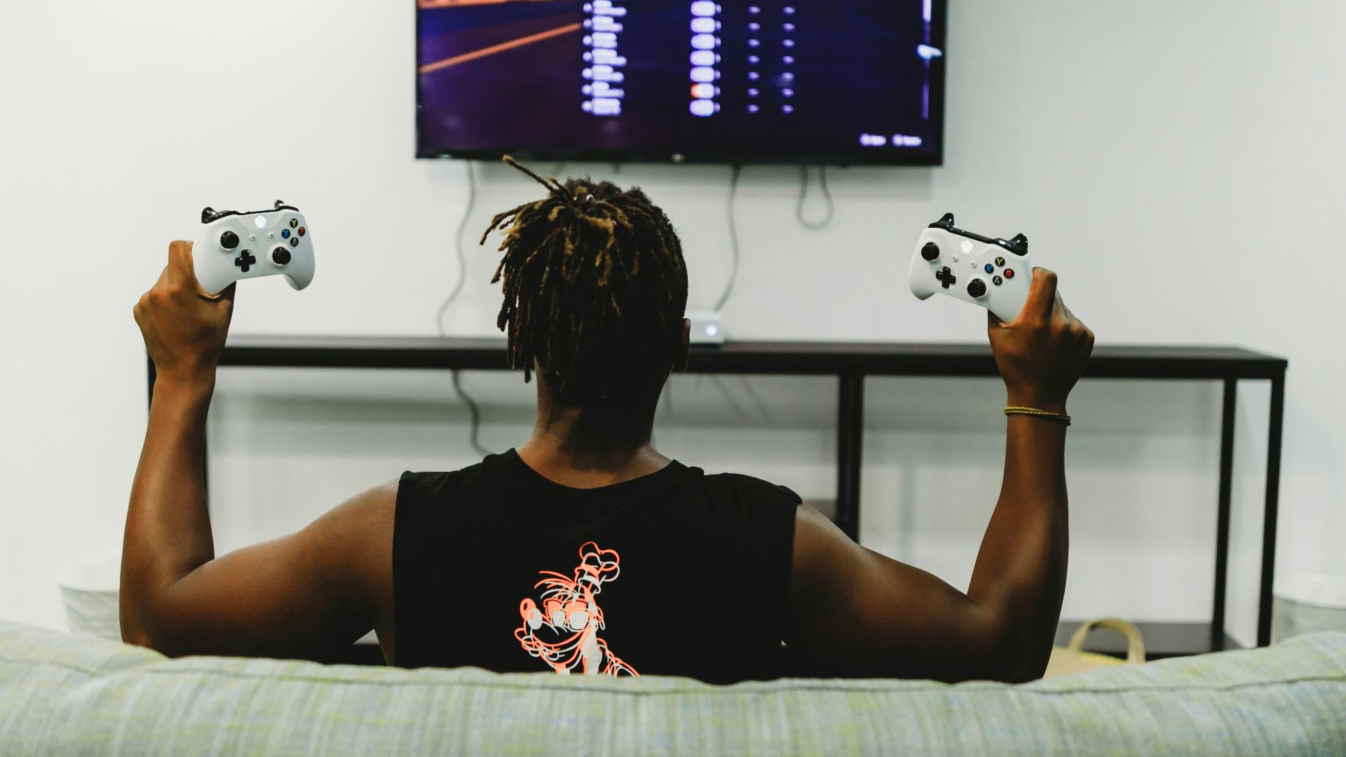 man sitting on couch holding controllers