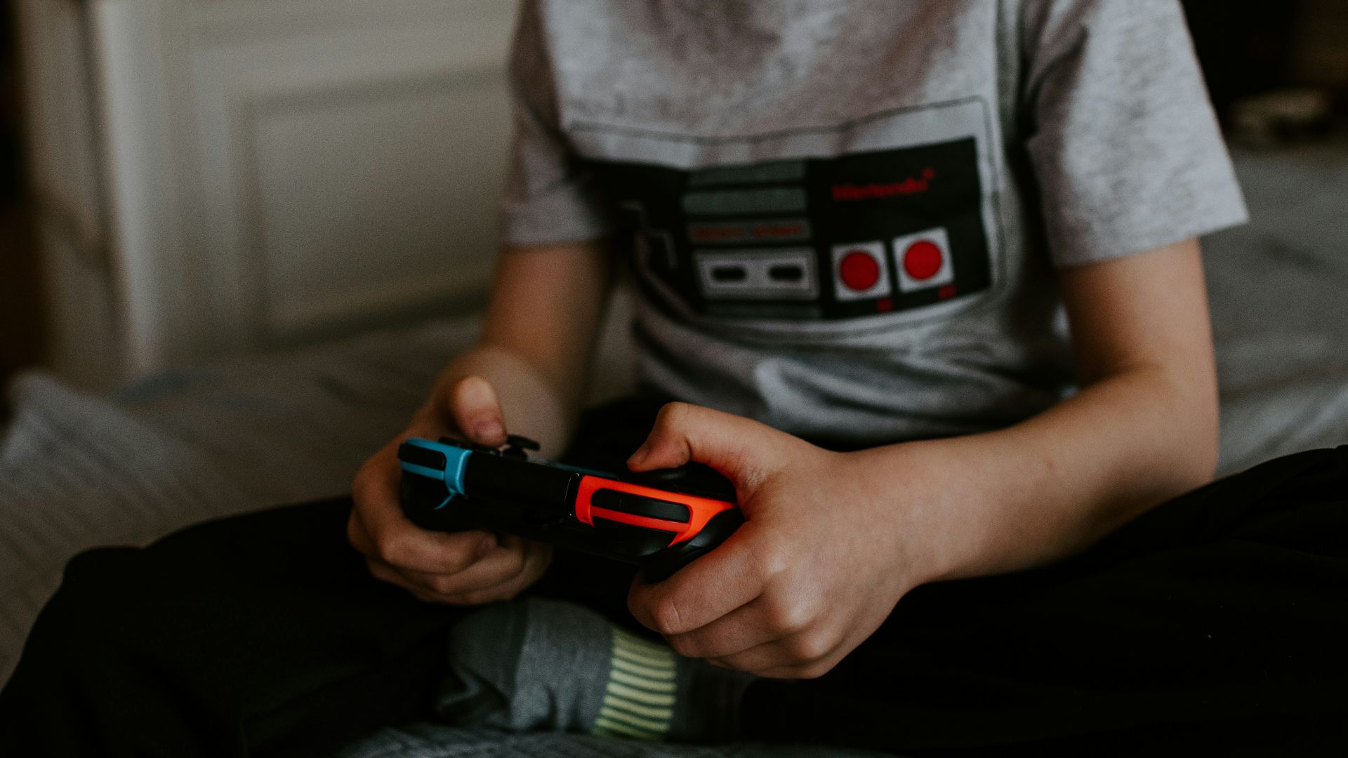 kid sitting on gray bed while playing