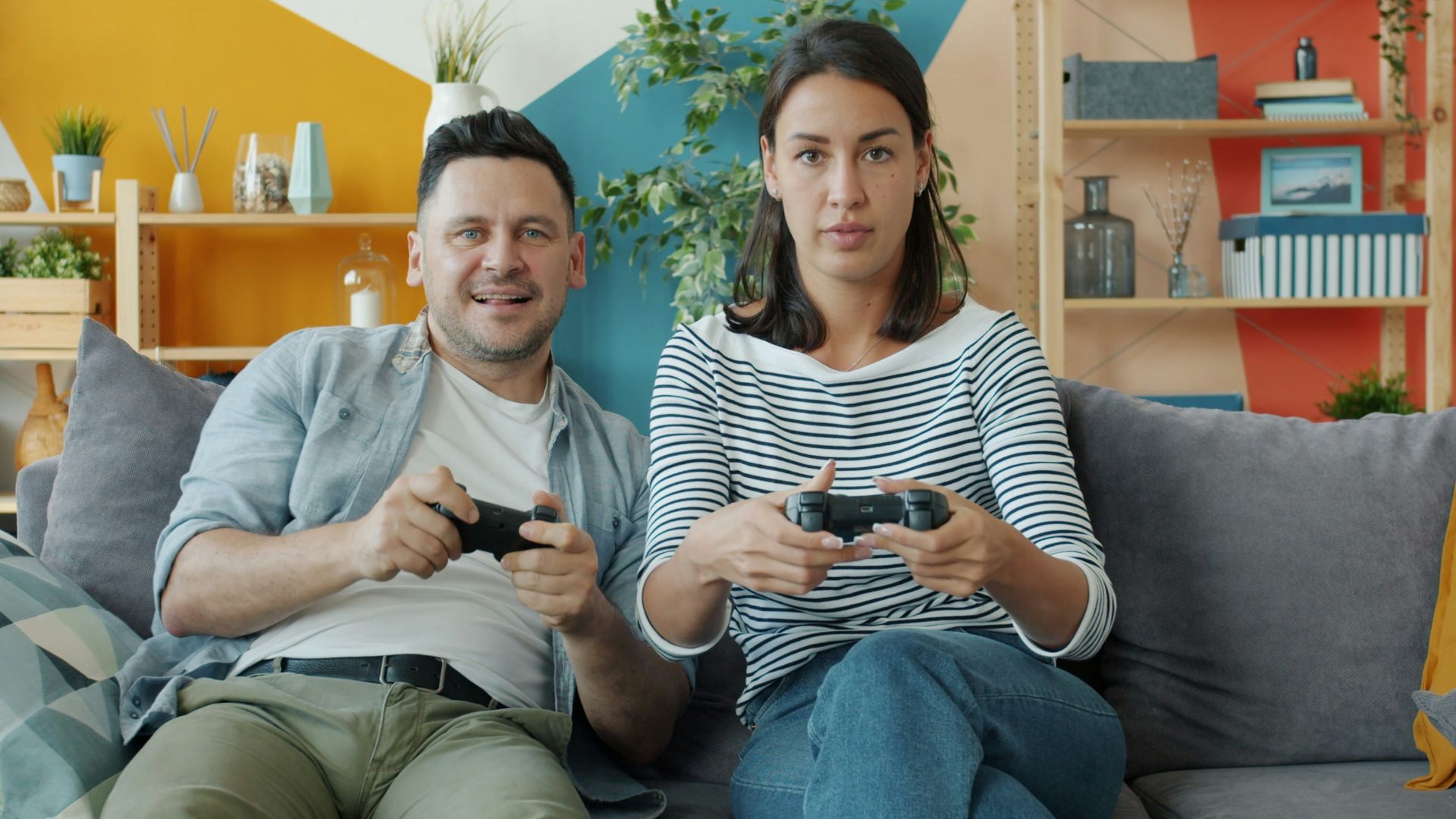 Couple playing video games on sofa