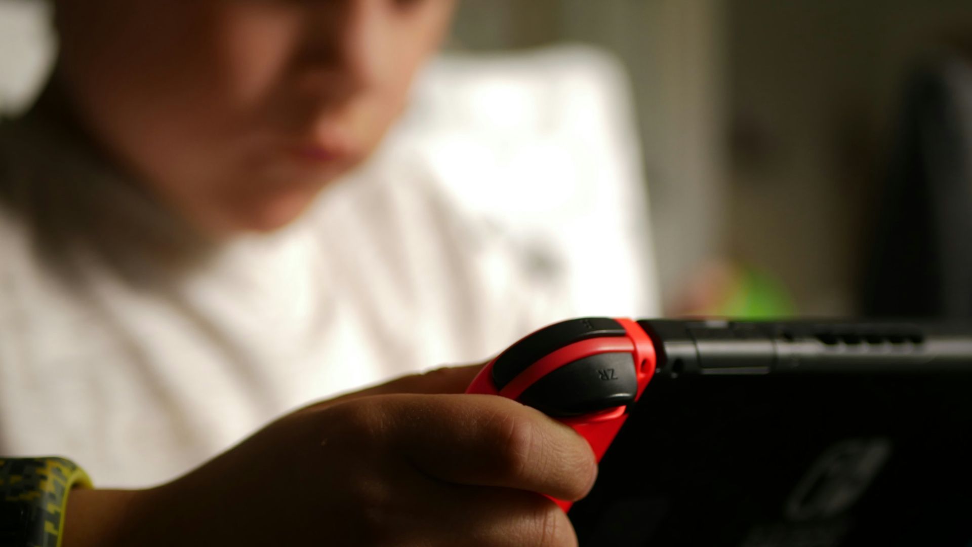 boy in white crew neck t-shirt holding black and red cordless device