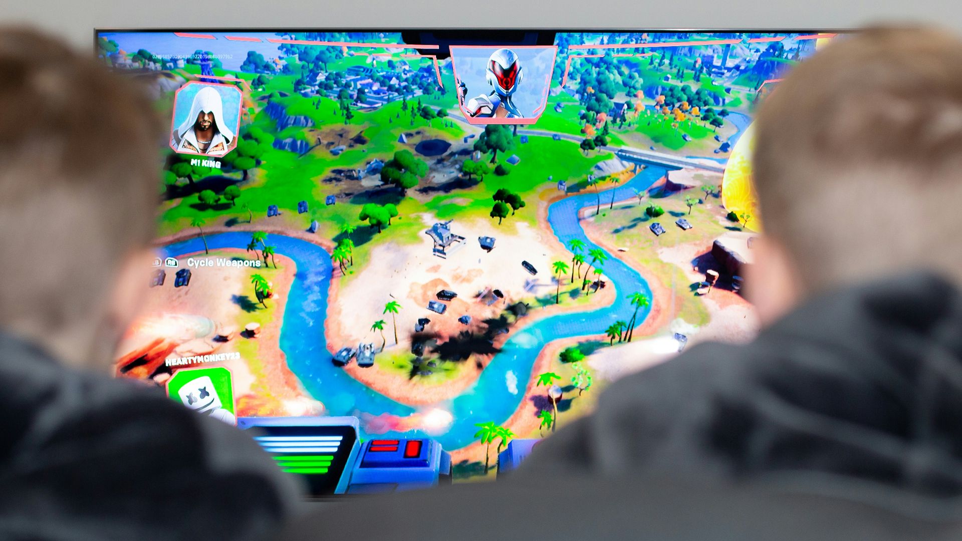 two boys are playing a video game on the television