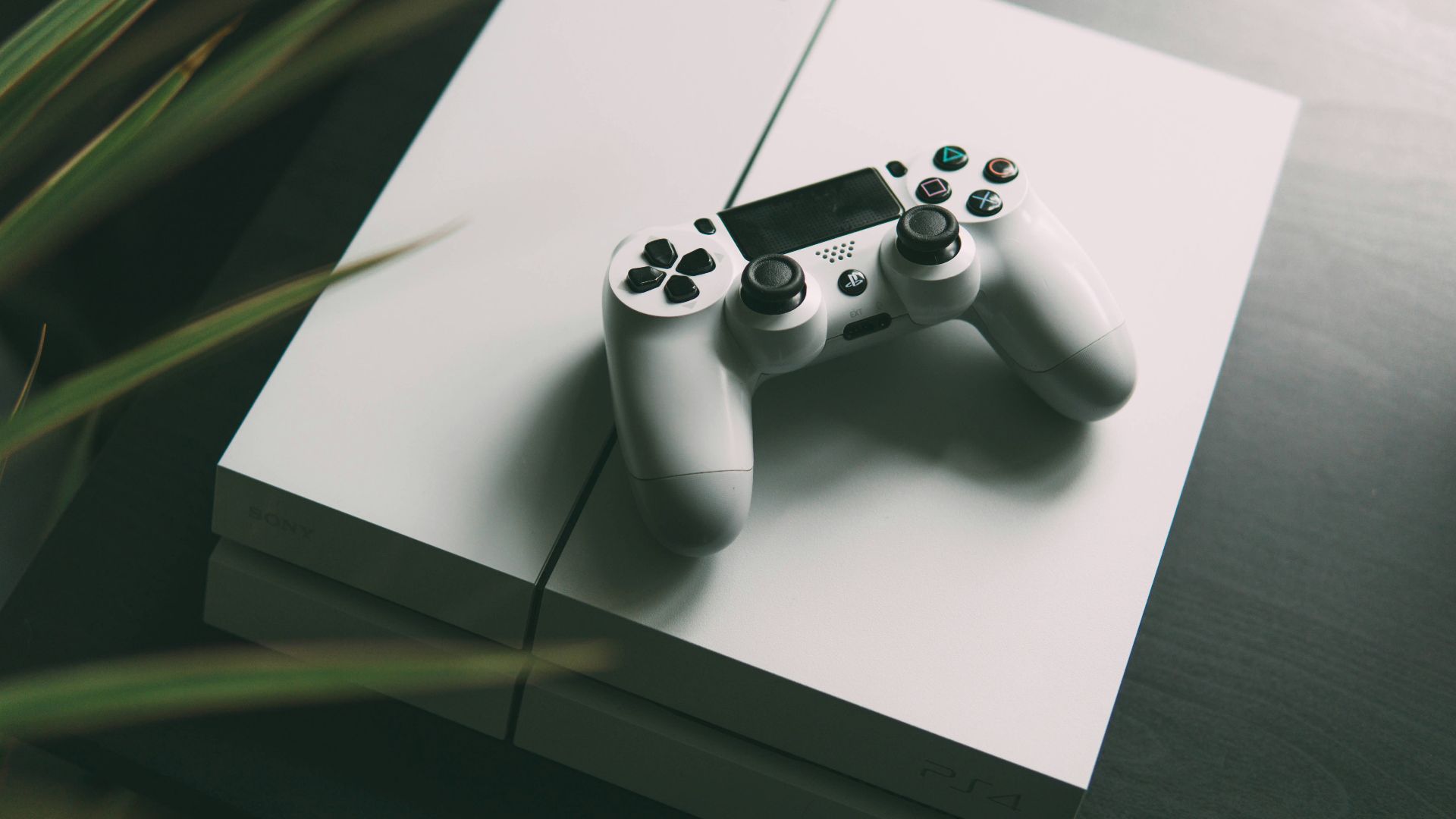 selective focus photography of white Sony PS4 console with wireless controller