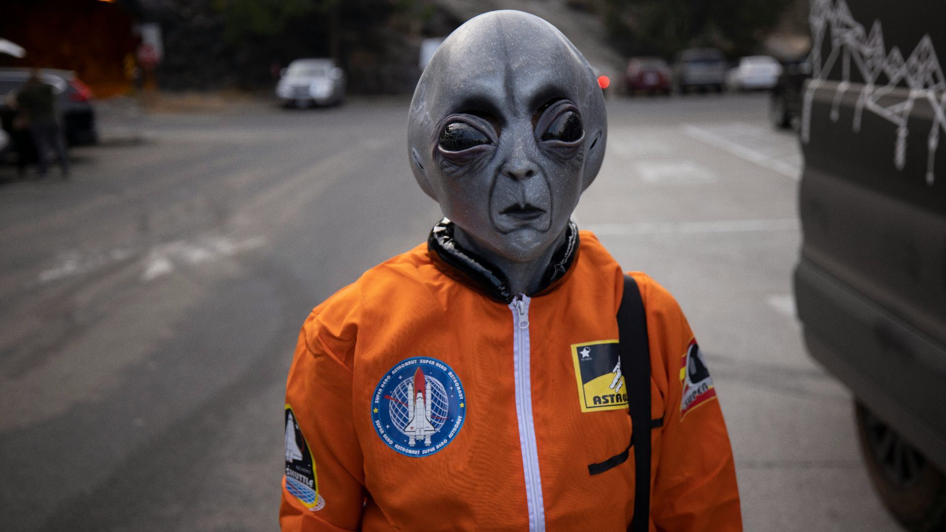 man in orange and white zip up jacket wearing white mask