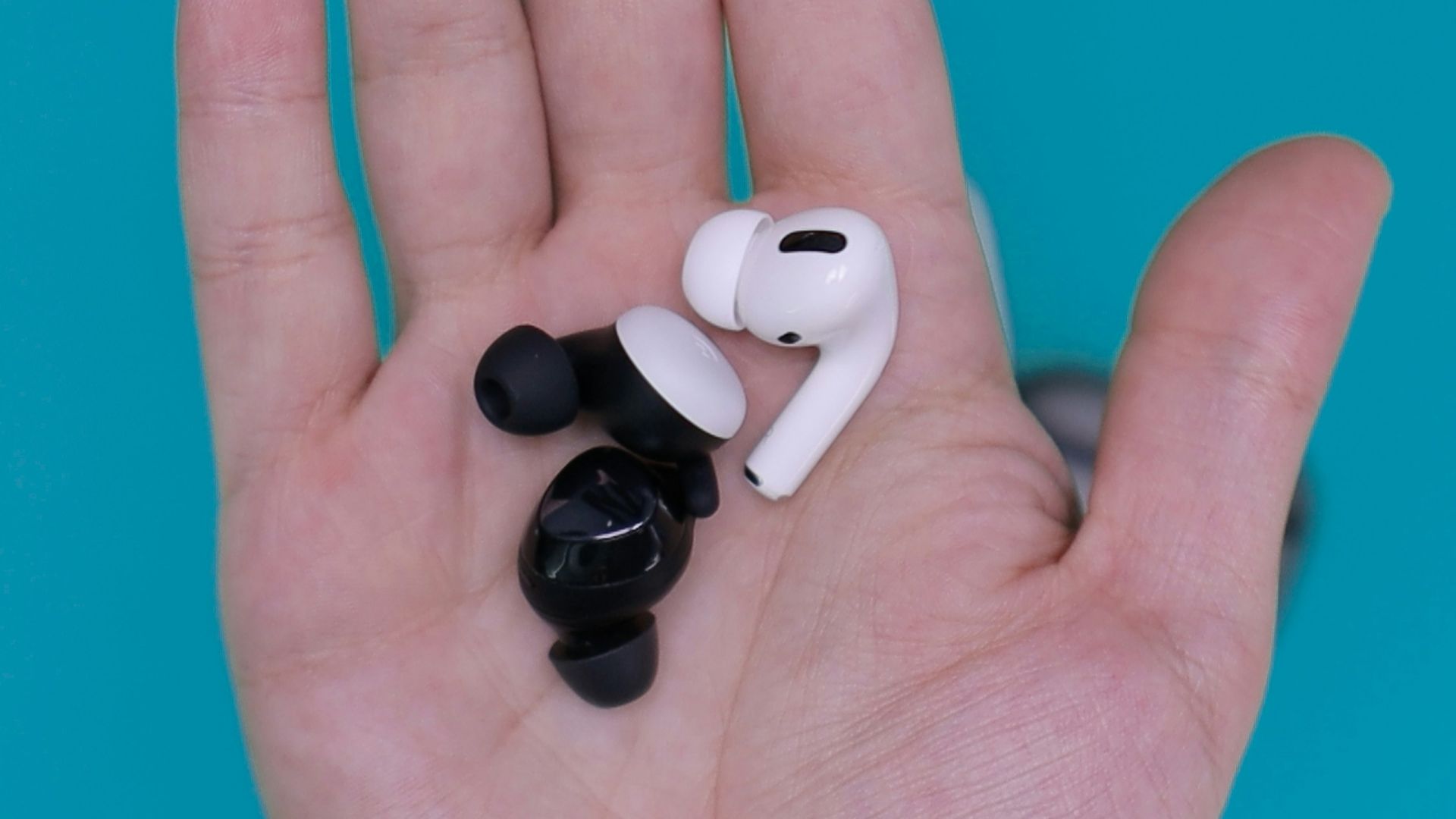 white and black earbuds on persons hand