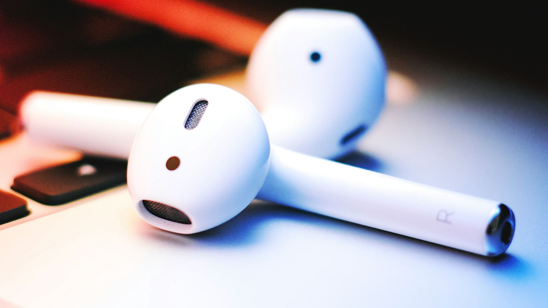 a pair of ear buds sitting on top of a laptop keyboard