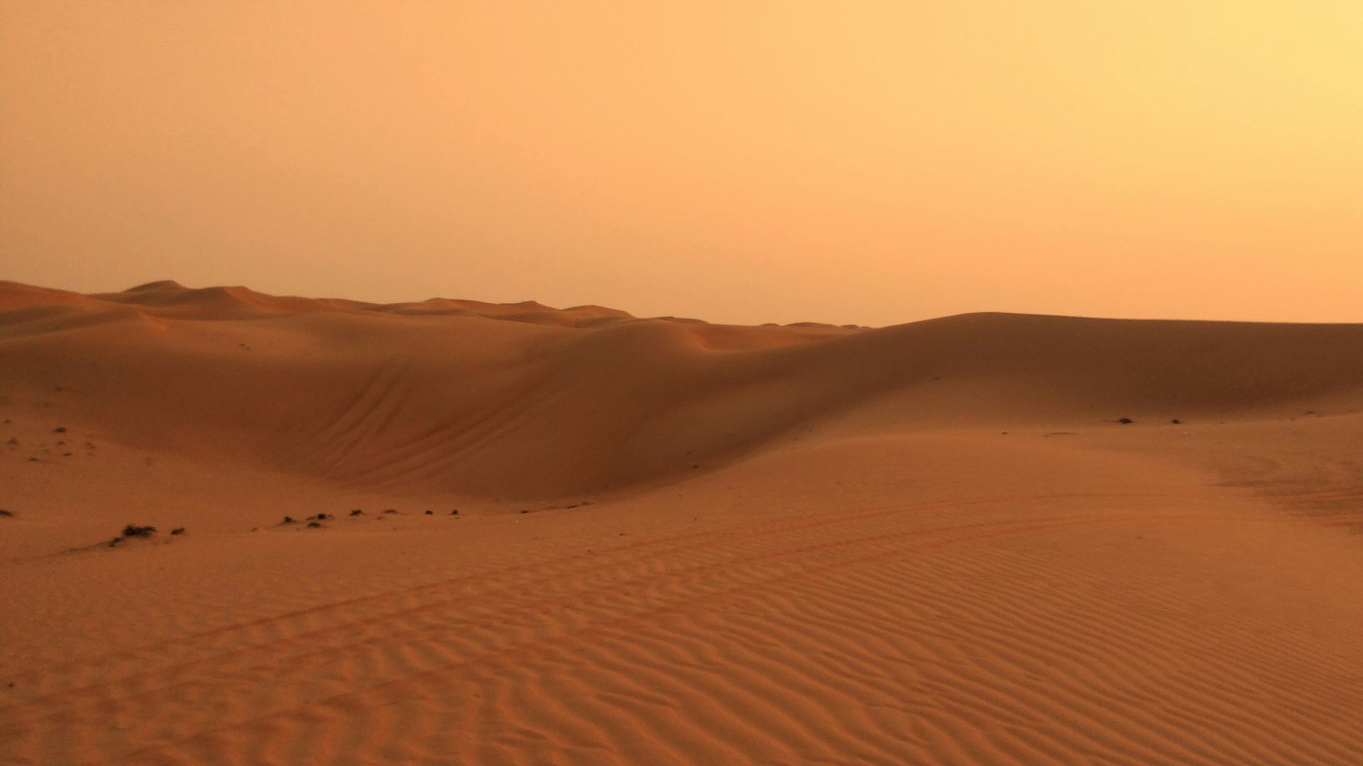 the sun is setting over the sand dunes