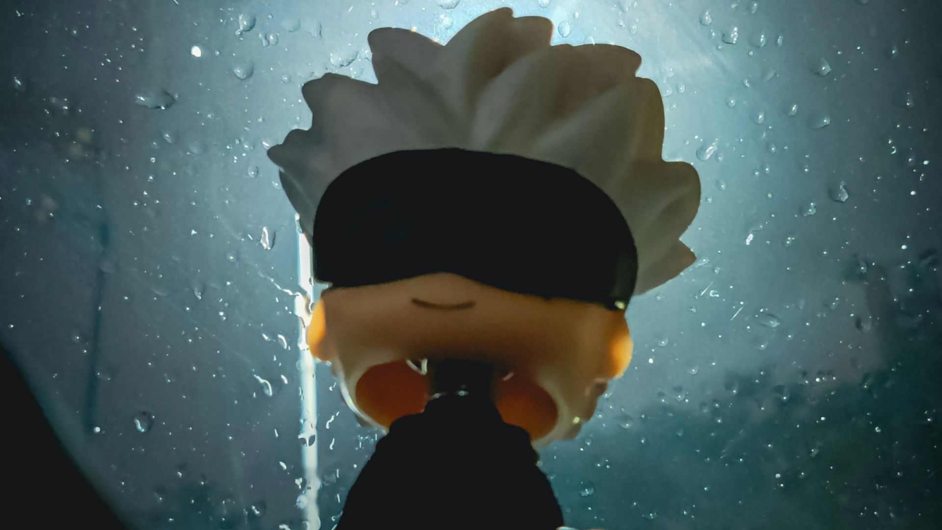 A person with a blindfolded head standing in front of a window