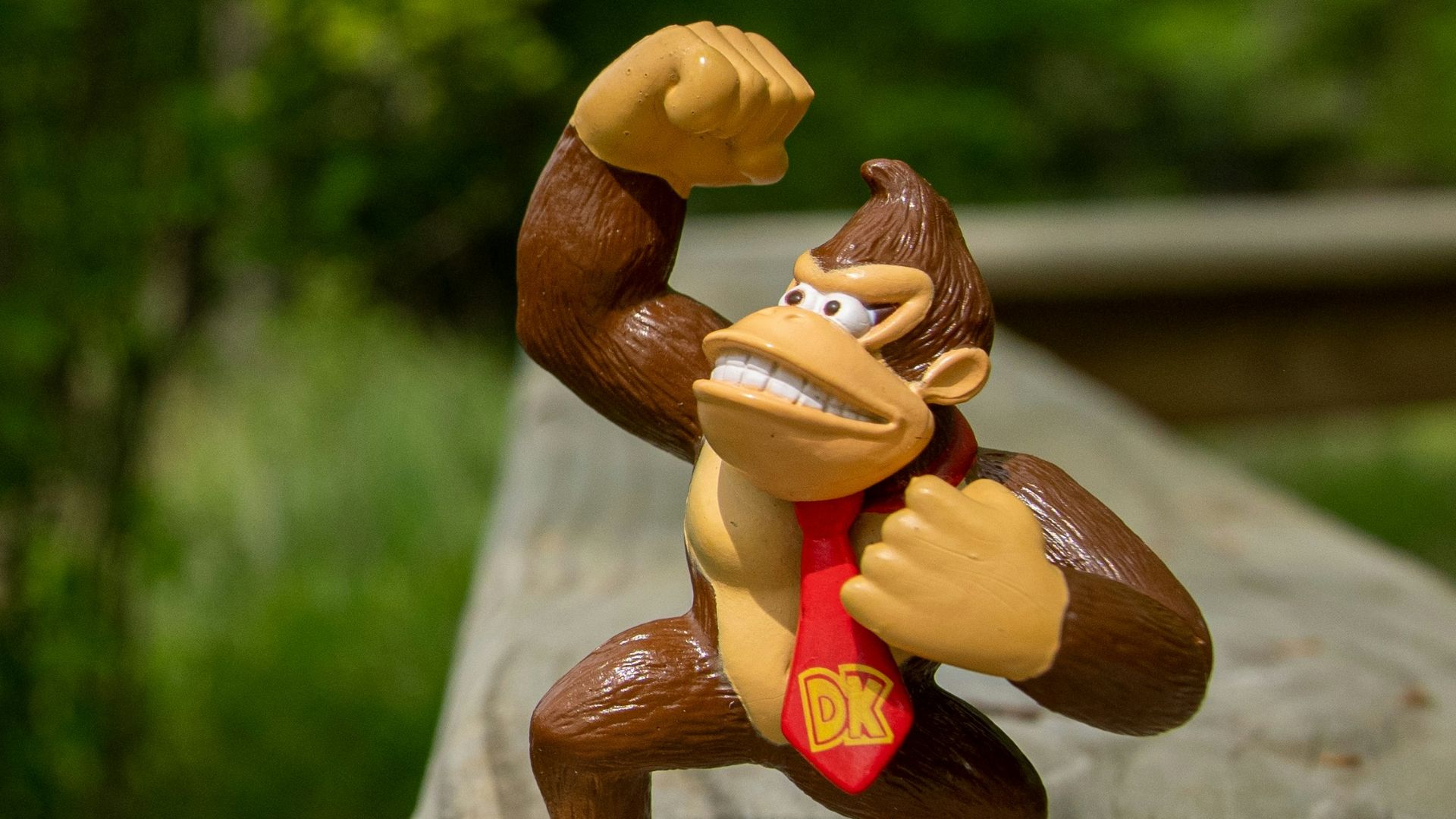 a monkey figurine is posed on a wooden deck