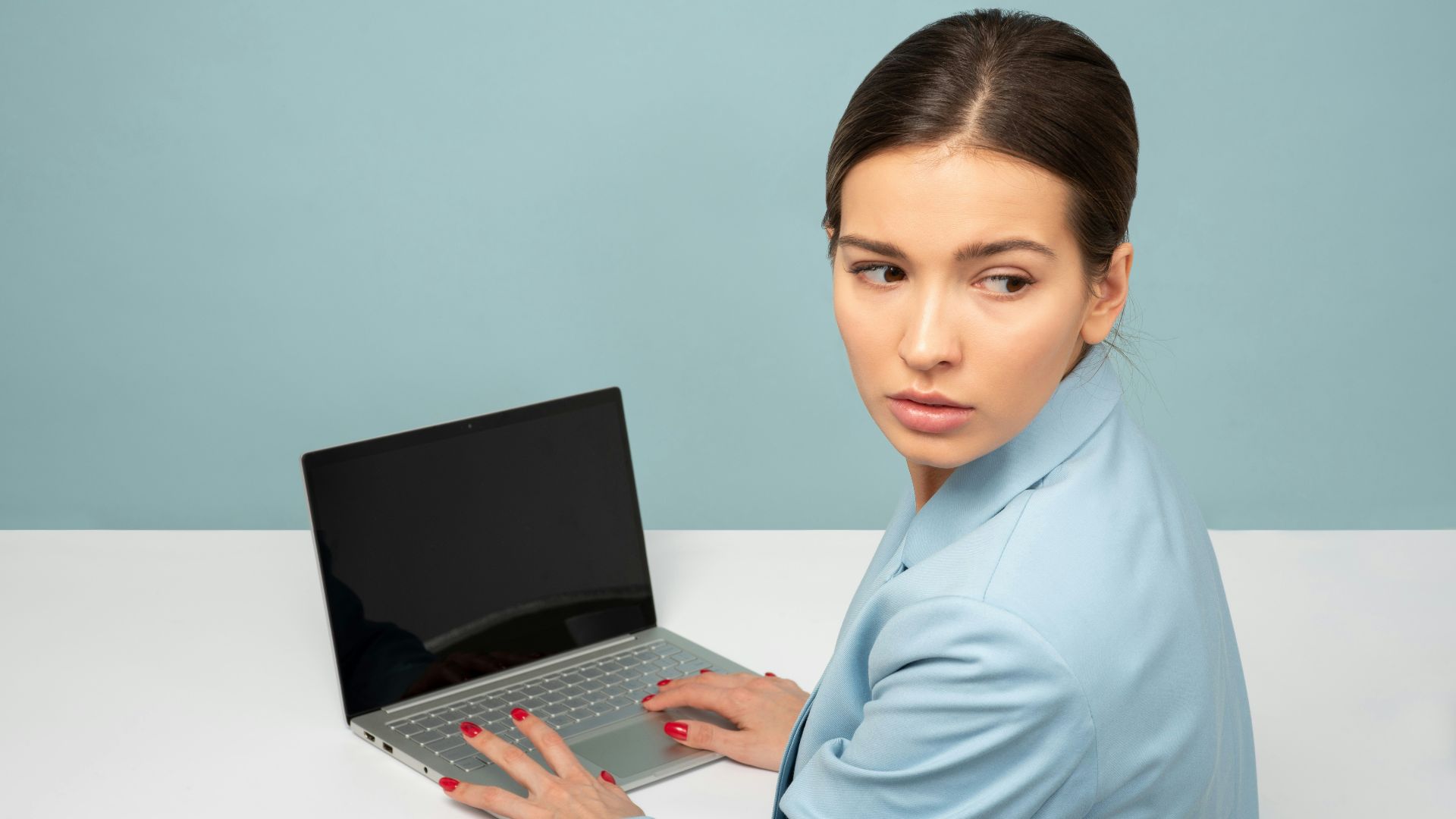 woman using laptop and looking side