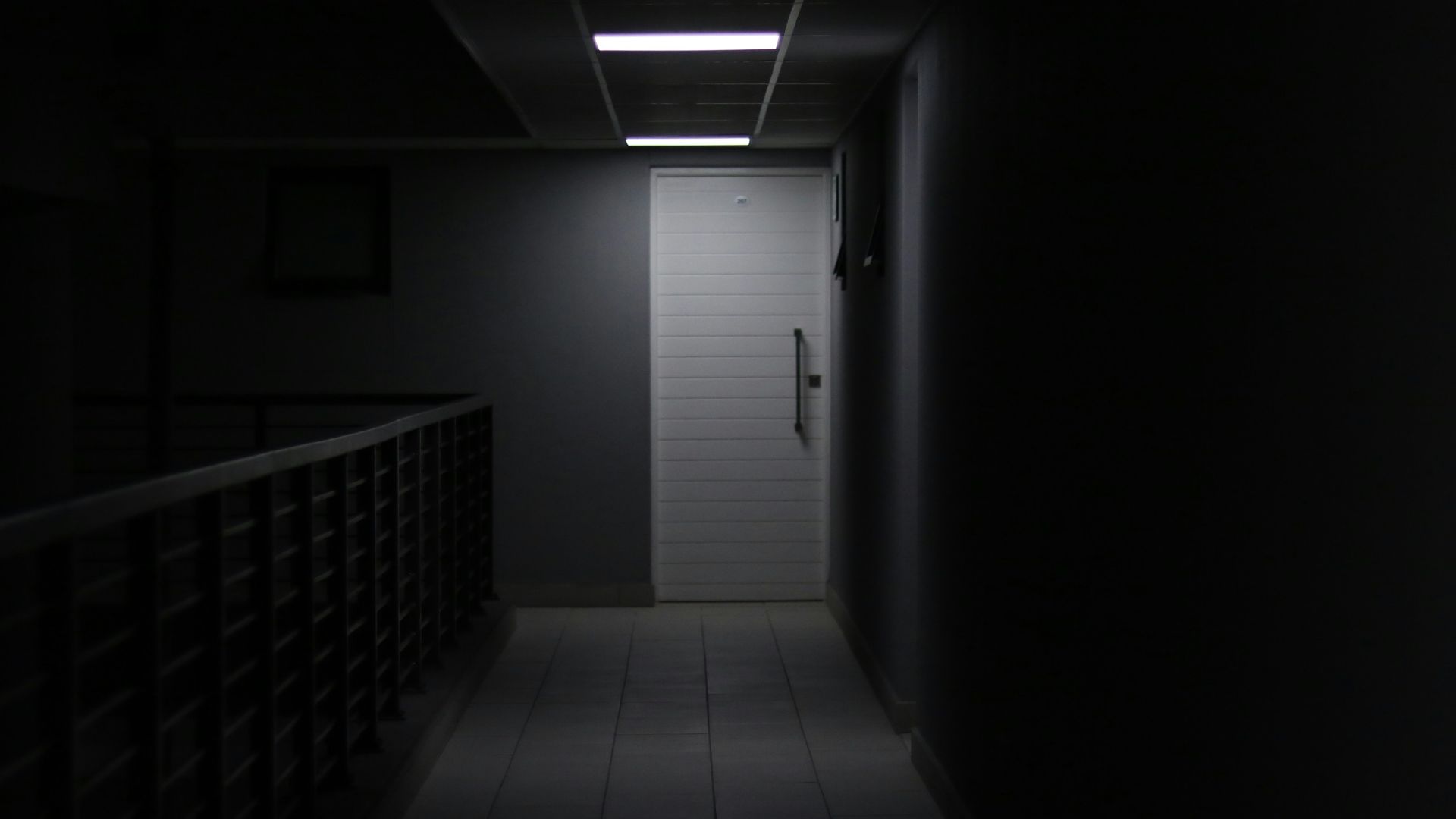 a dark hallway with a light at the end of the hallway
