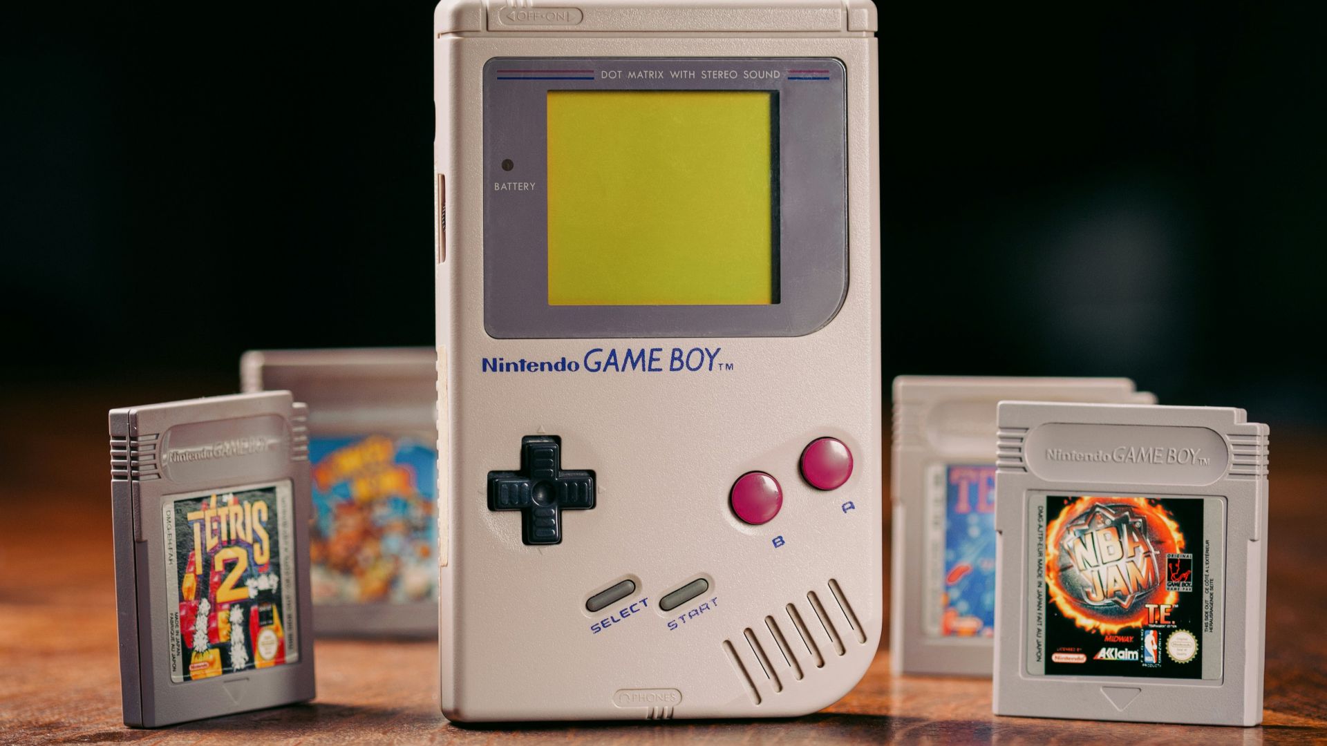 a nintendo game boy sitting on top of a wooden table