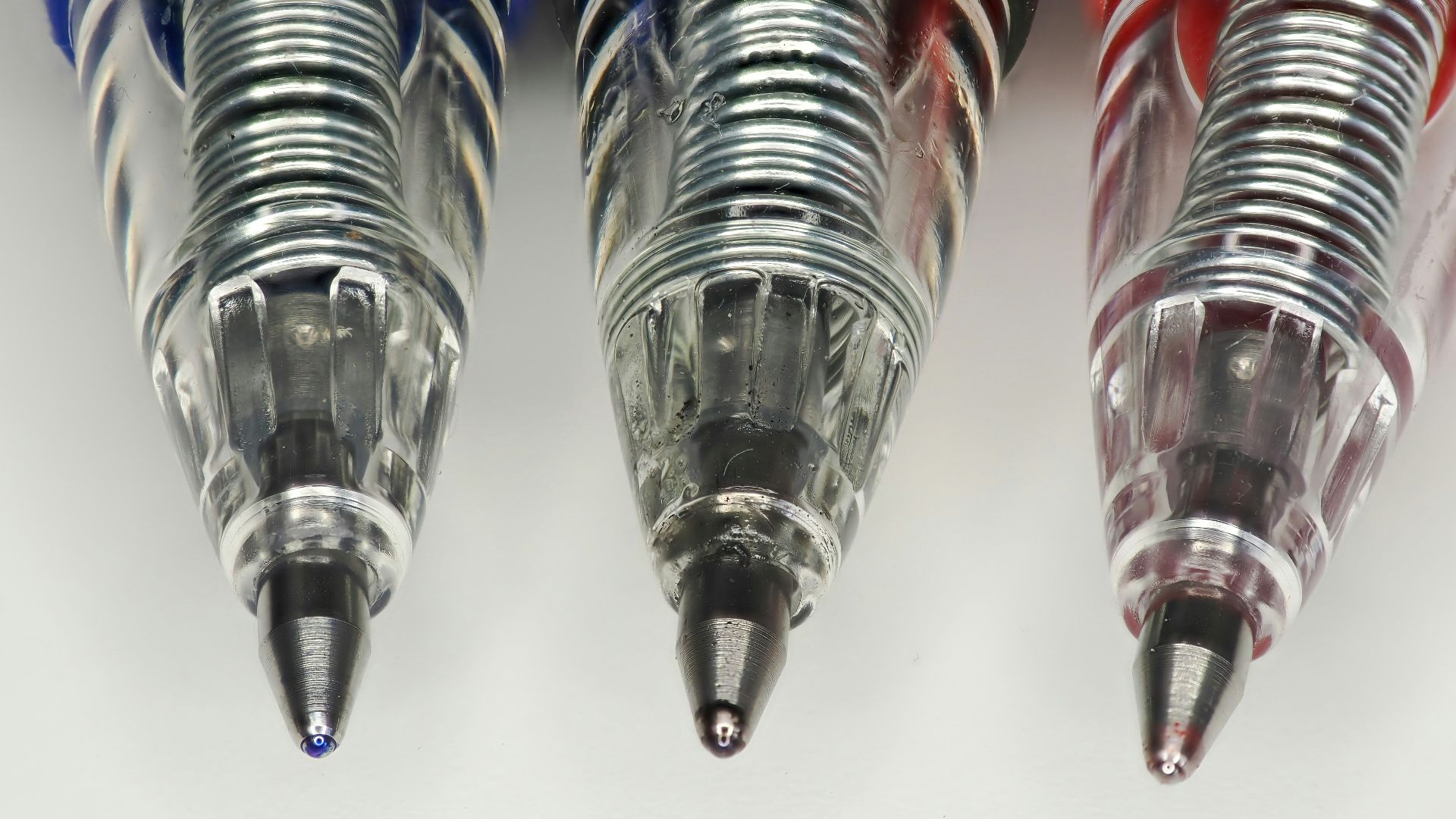 four different colored pens lined up in a row