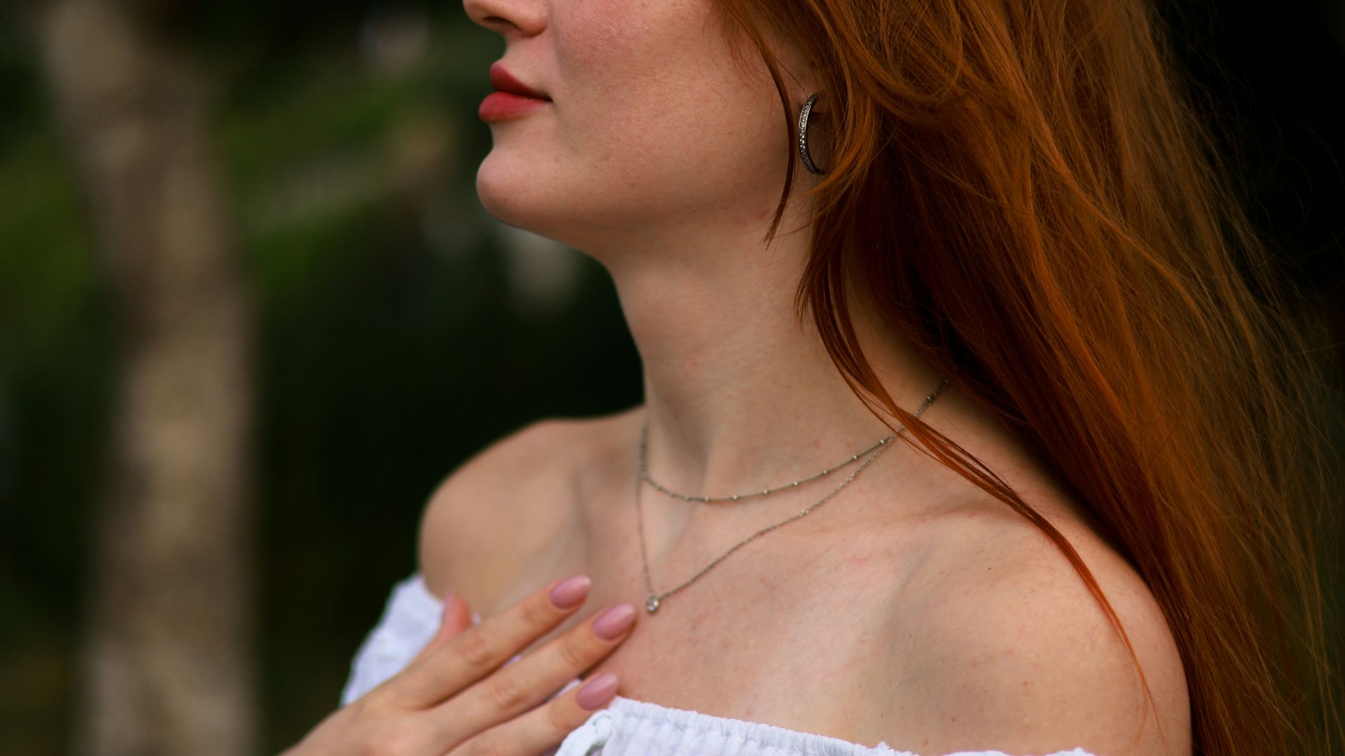 a woman with red hair wearing a white shirt