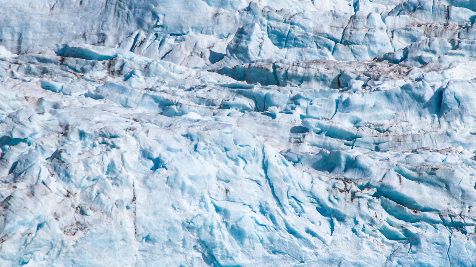a large glacier with a boat in the water