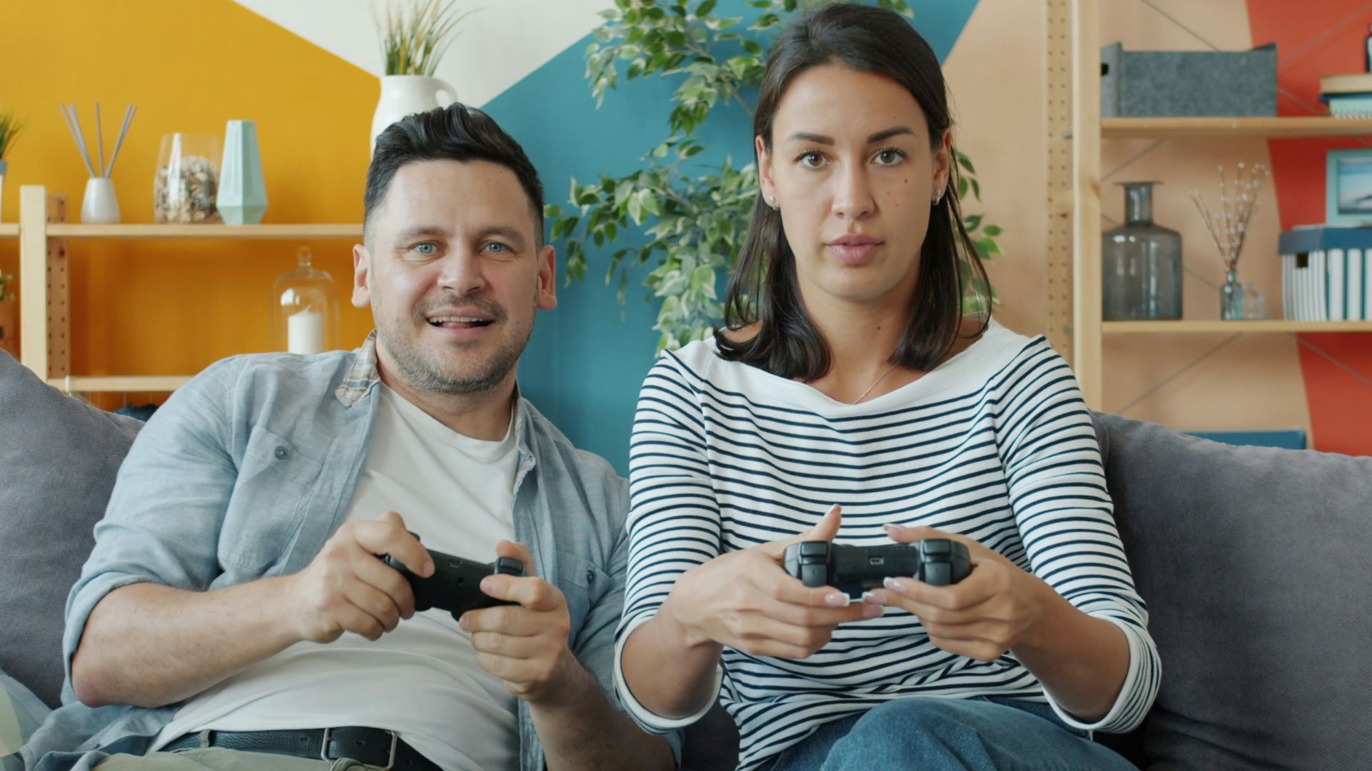 Couple playing video games on sofa