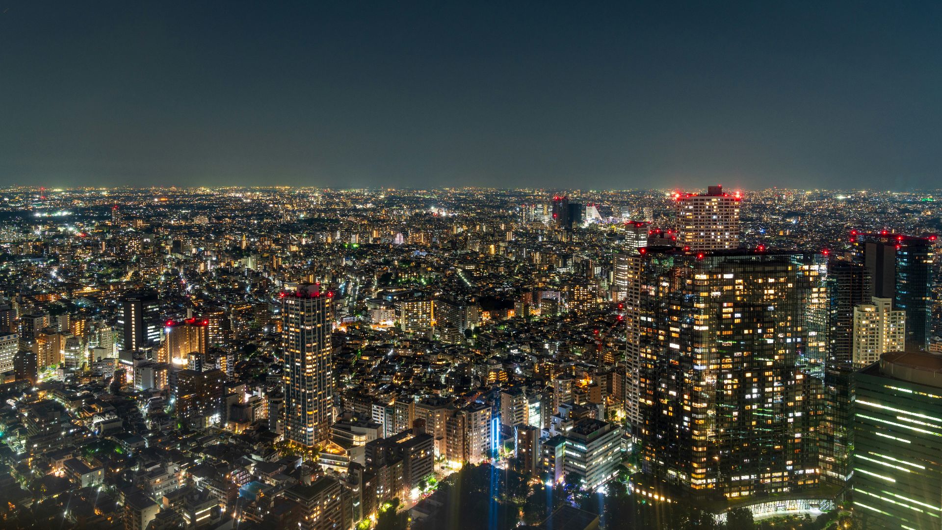 a view of a city at night from the top of a skyscraper