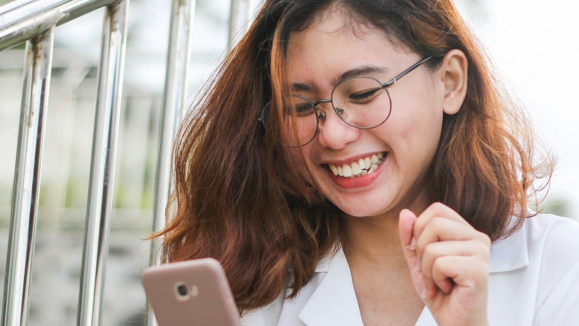 woman in white button up shirt holding silver iphone 6
