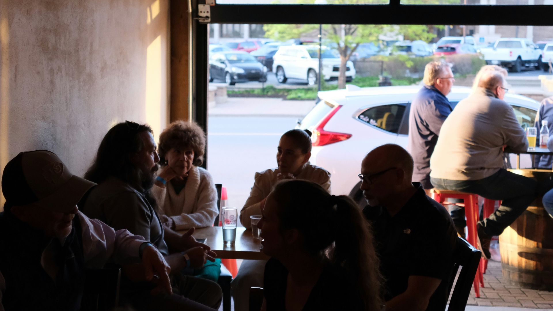 People gather inside a restaurant with an open door.