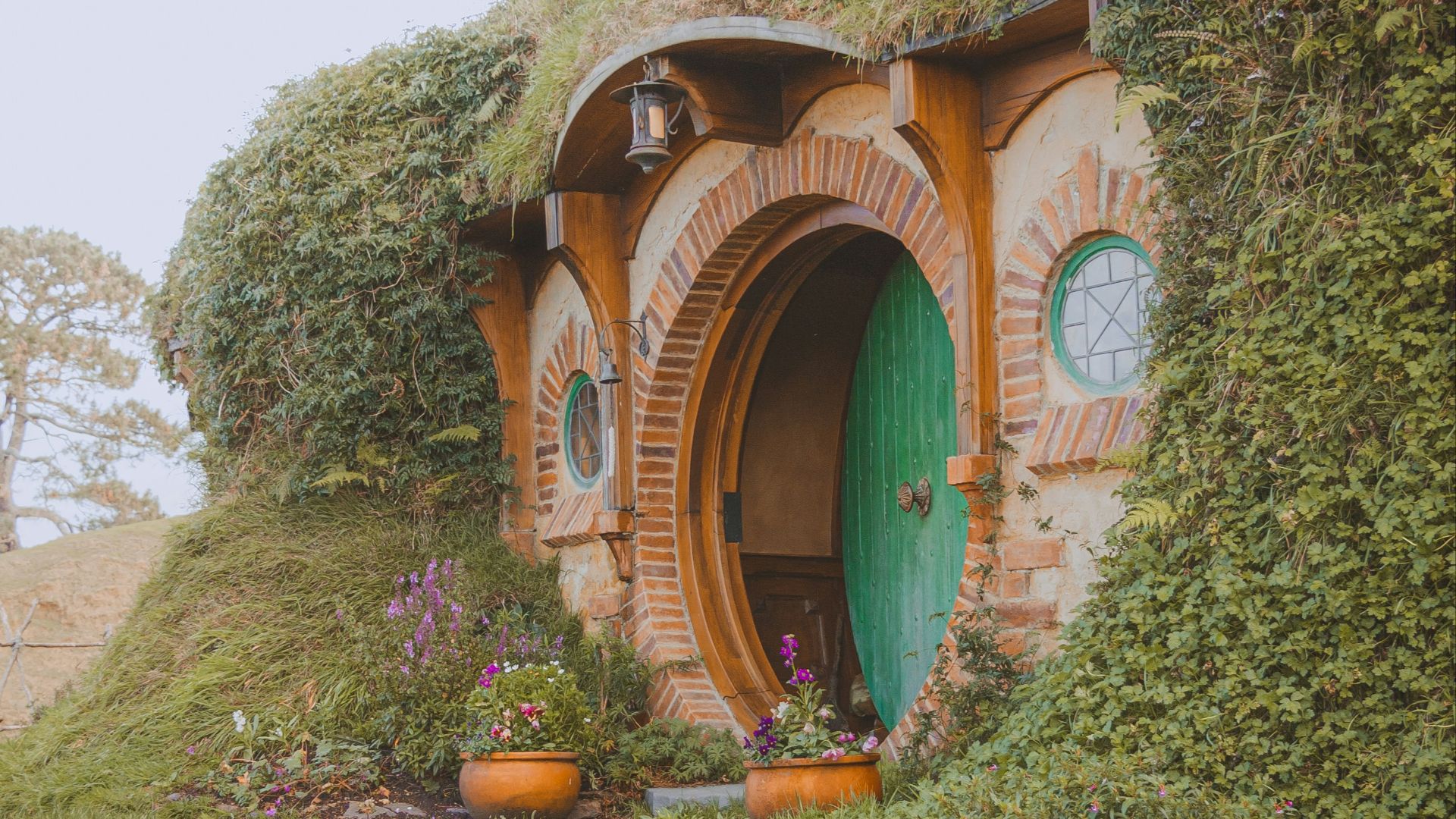 a hobbot with a green door and steps leading up to it