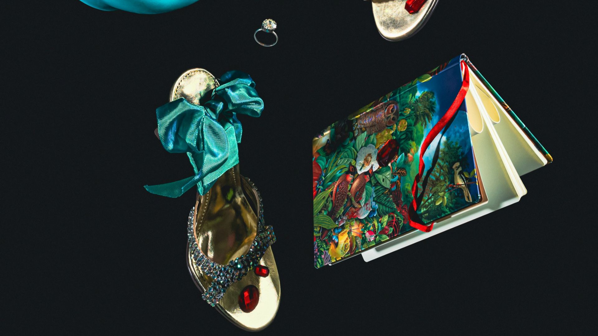 a teapot, a book, and a pair of shoes on a black background