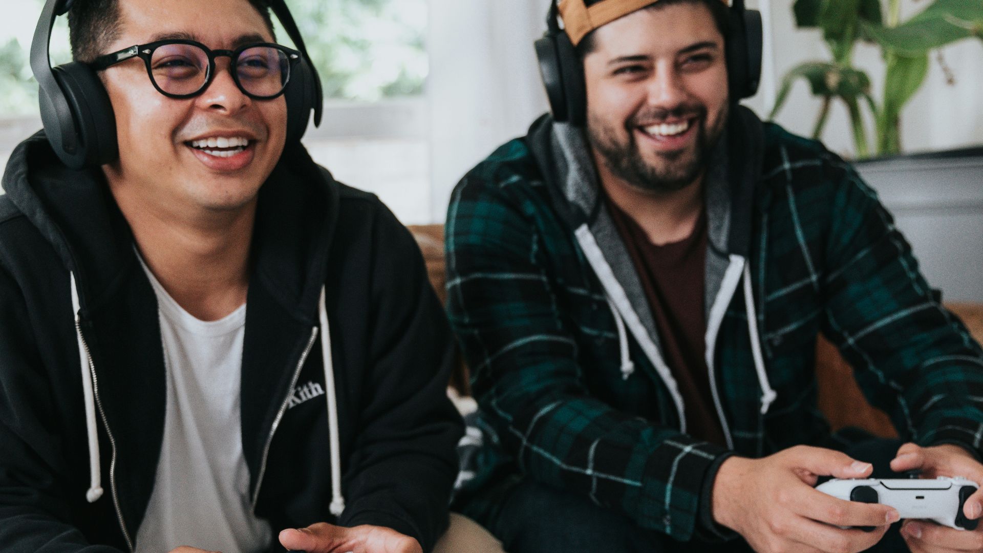 a couple of men sitting at a table with game controllers