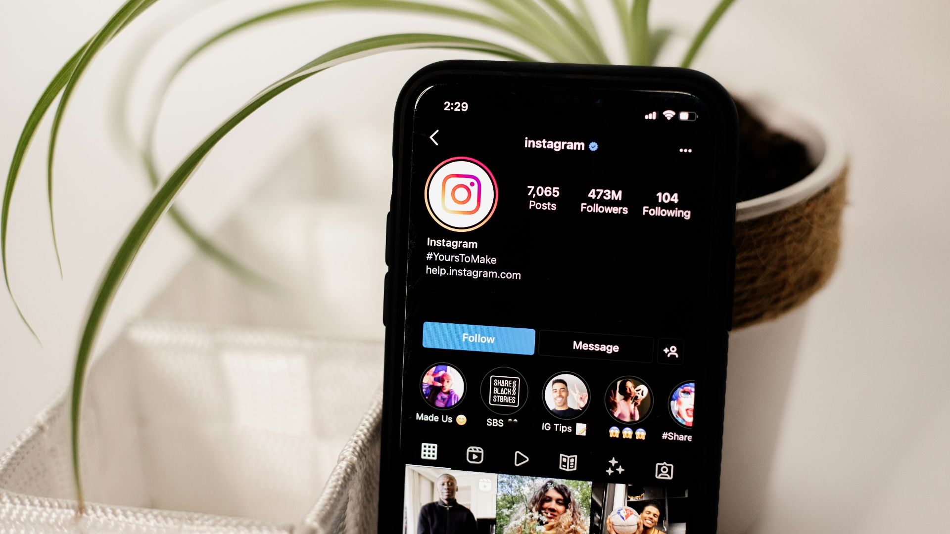 a cell phone sitting on top of a table next to a potted plant