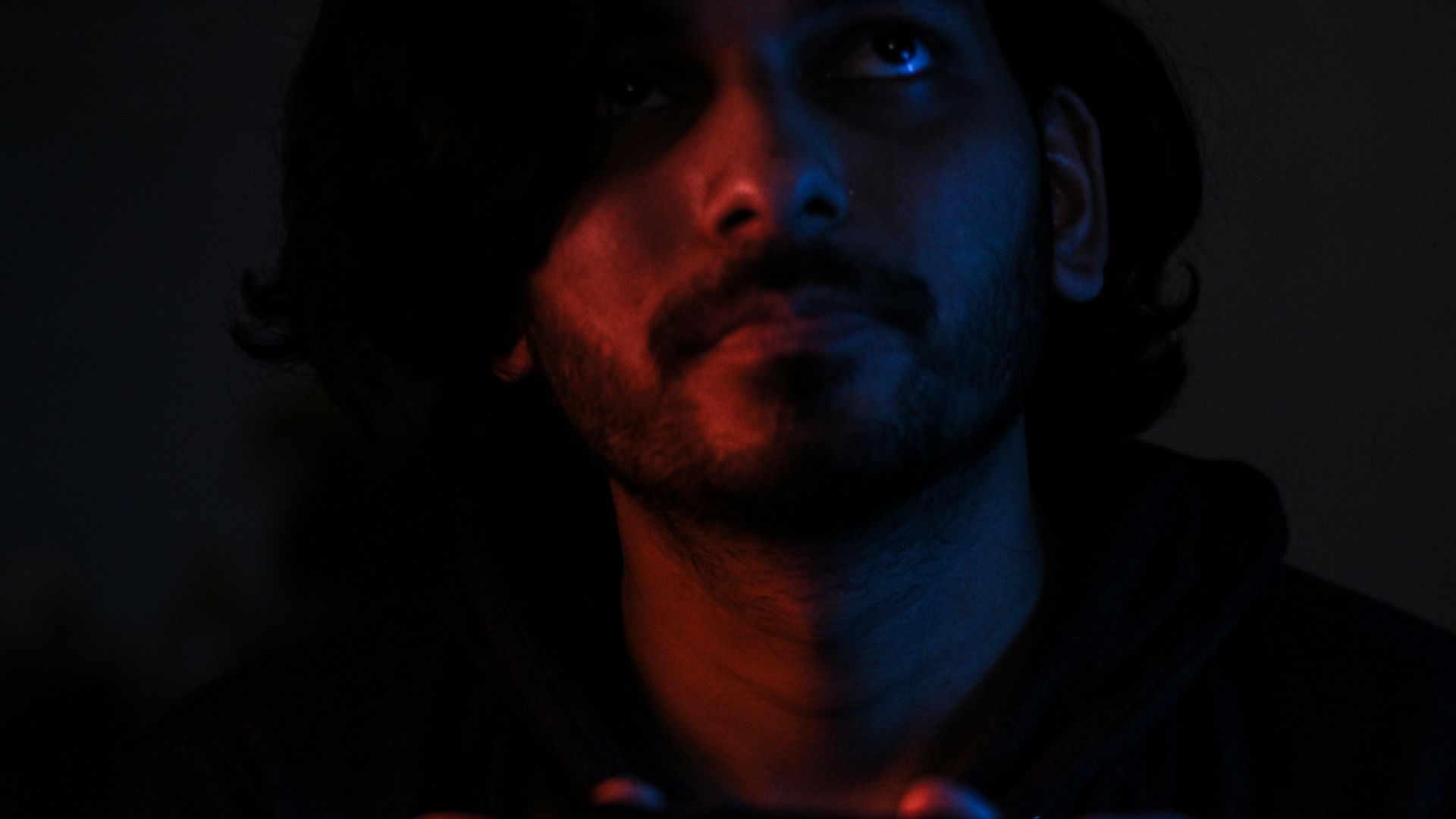 man in black jacket holding black smartphone