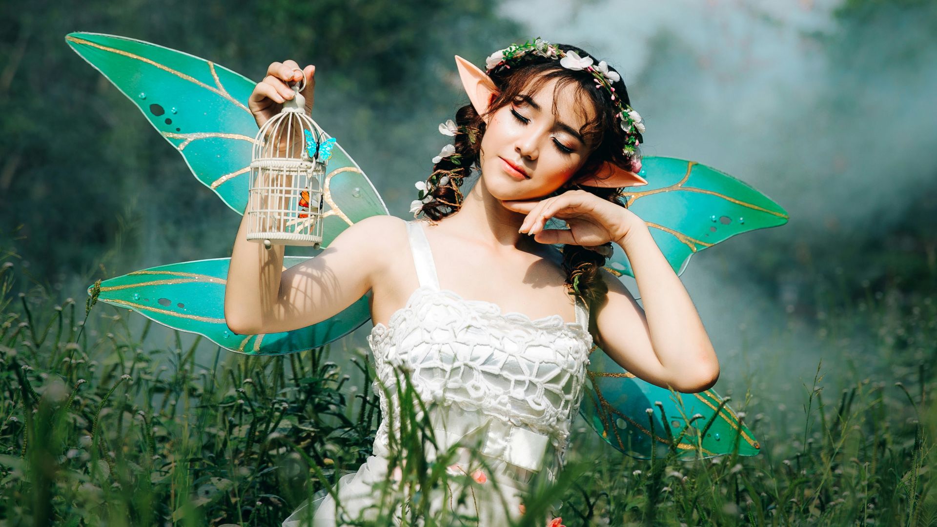 woman in white dress wearing green fairy wings