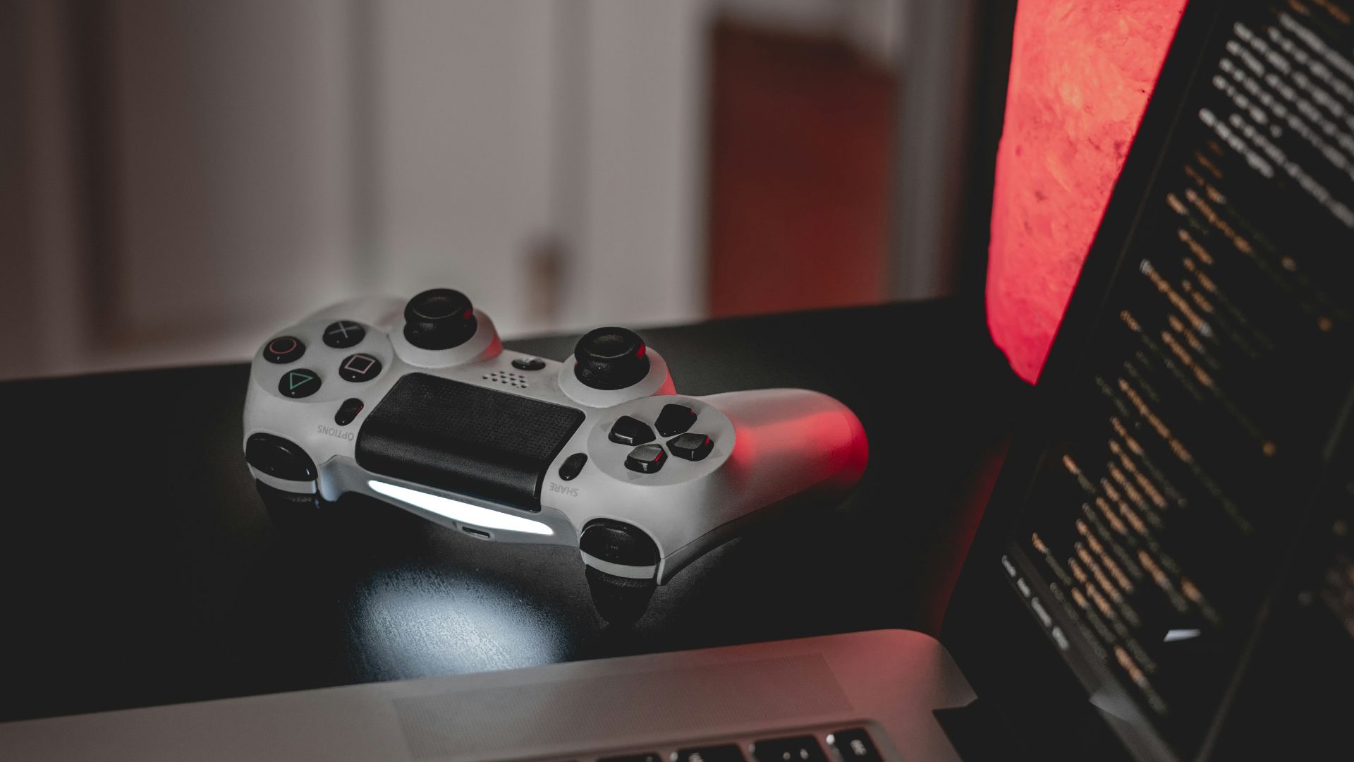 white and black game controller on macbook pro