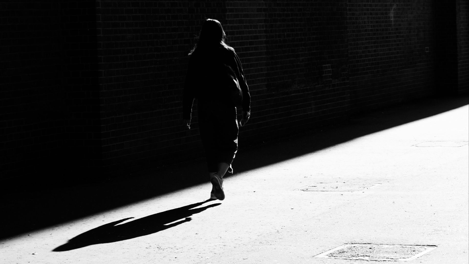 grayscale photography of person walking on pathway