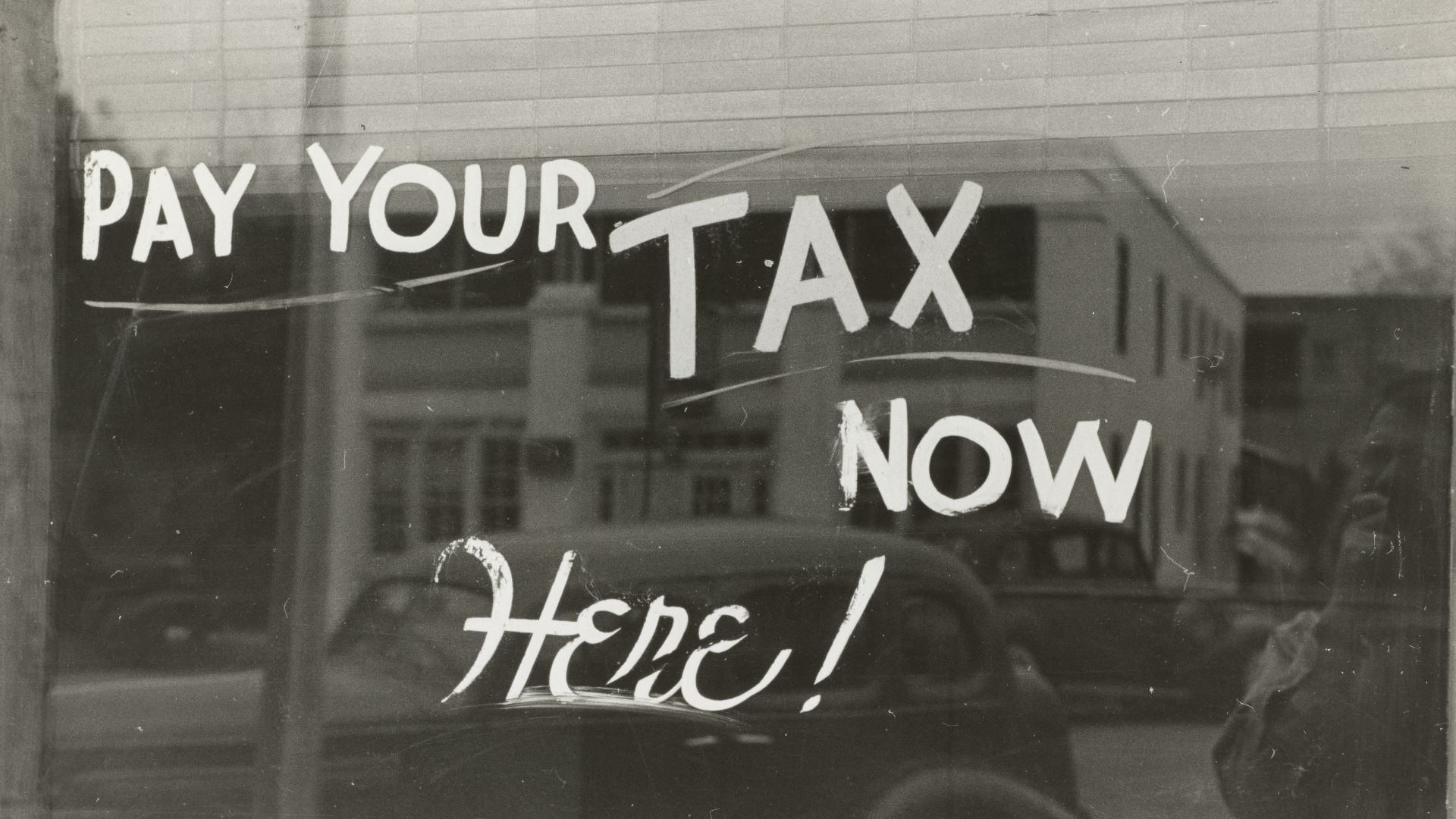 a sign that says pay your tax now here