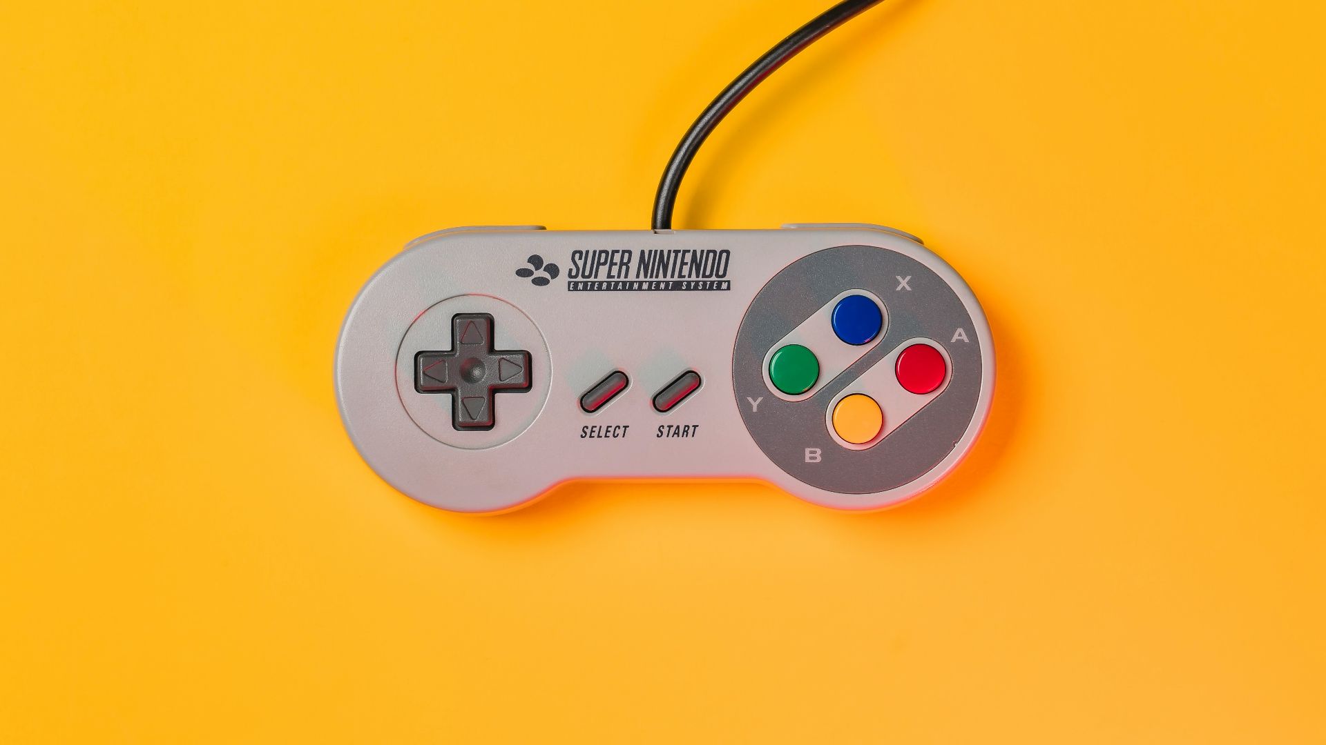 white nintendo game controller on yellow surface