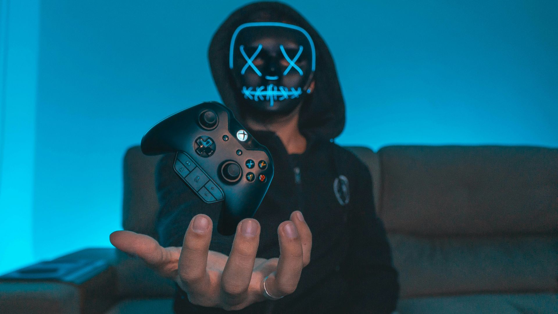 person sitting on chair while holding Xbox One controller