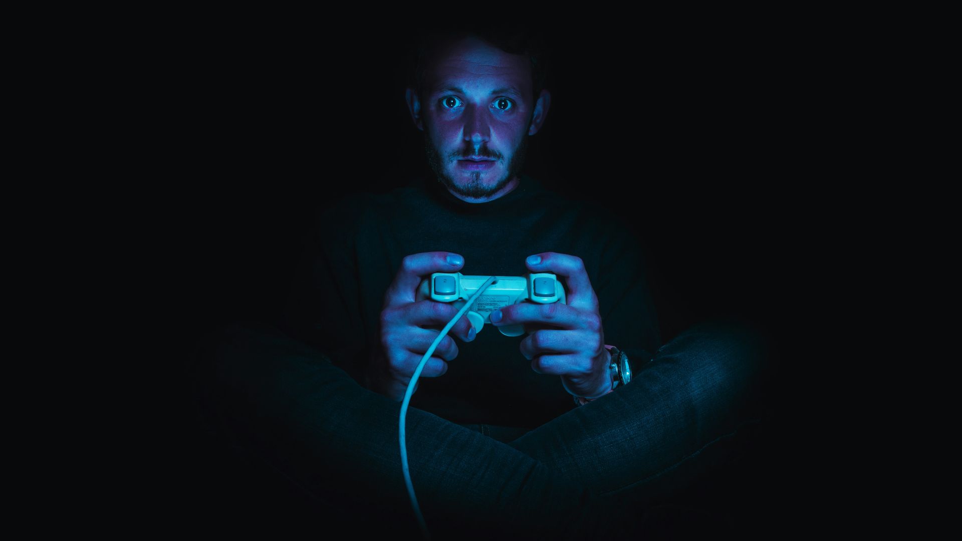 man holding corded game controller
