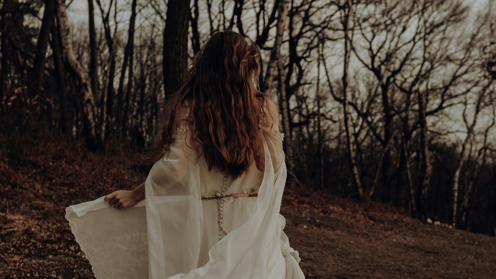 woman in white dress standing on brown soil