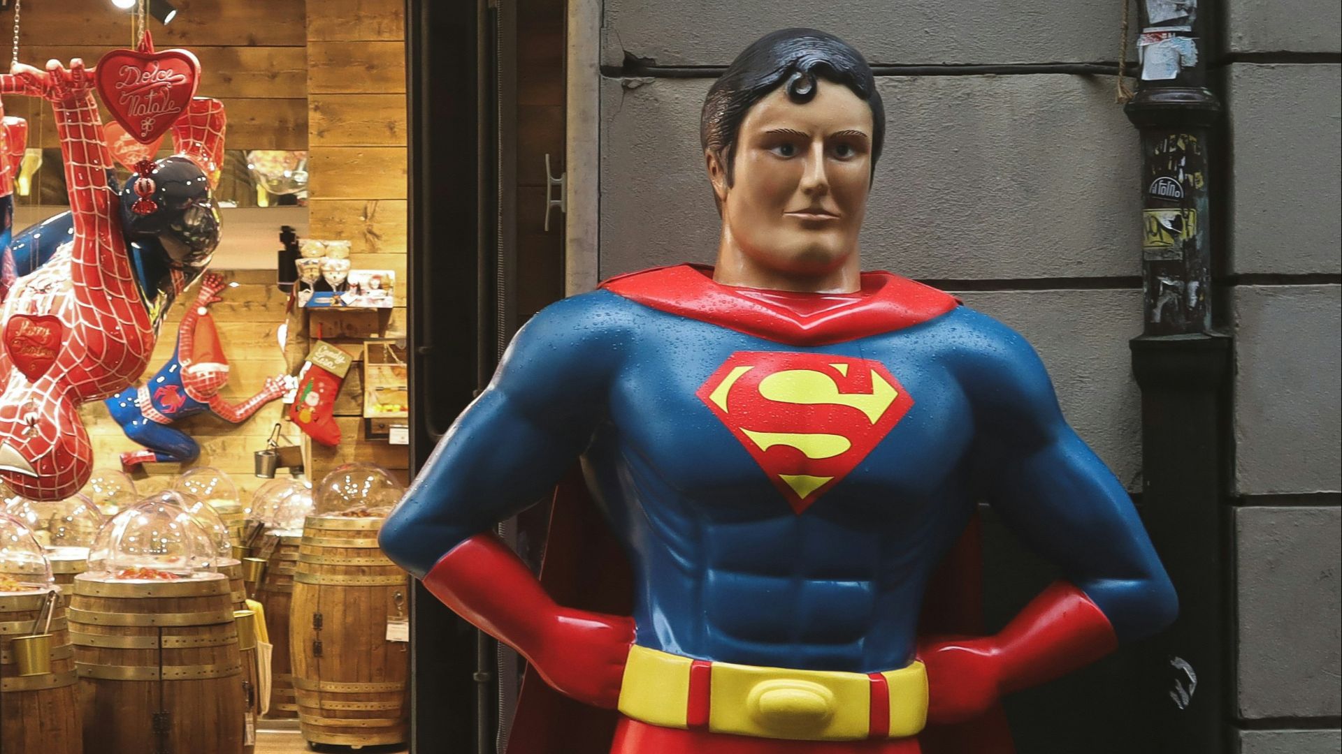 a statue of a superman stands in front of a store