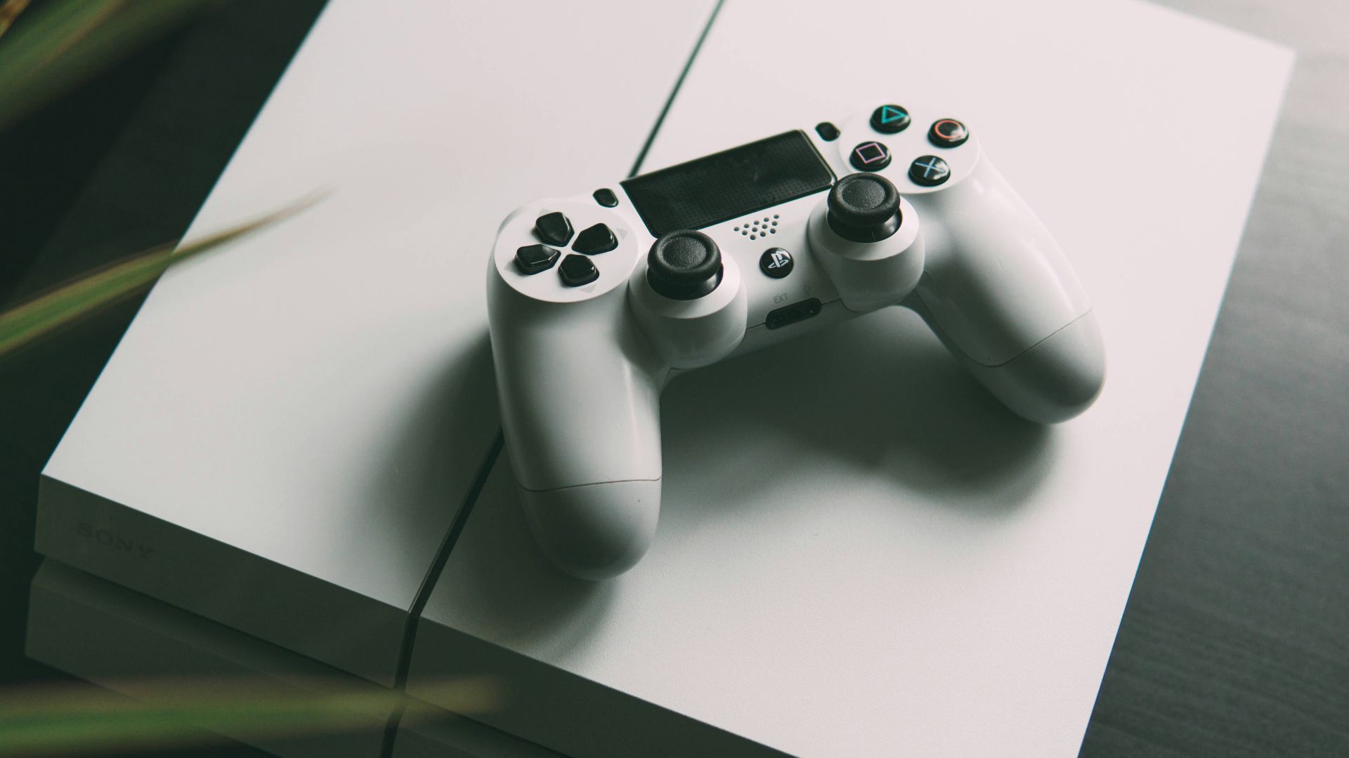 selective focus photography of white Sony PS4 console with wireless controller